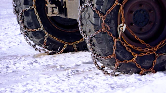 Tires are covered in chains for snowy conditions.