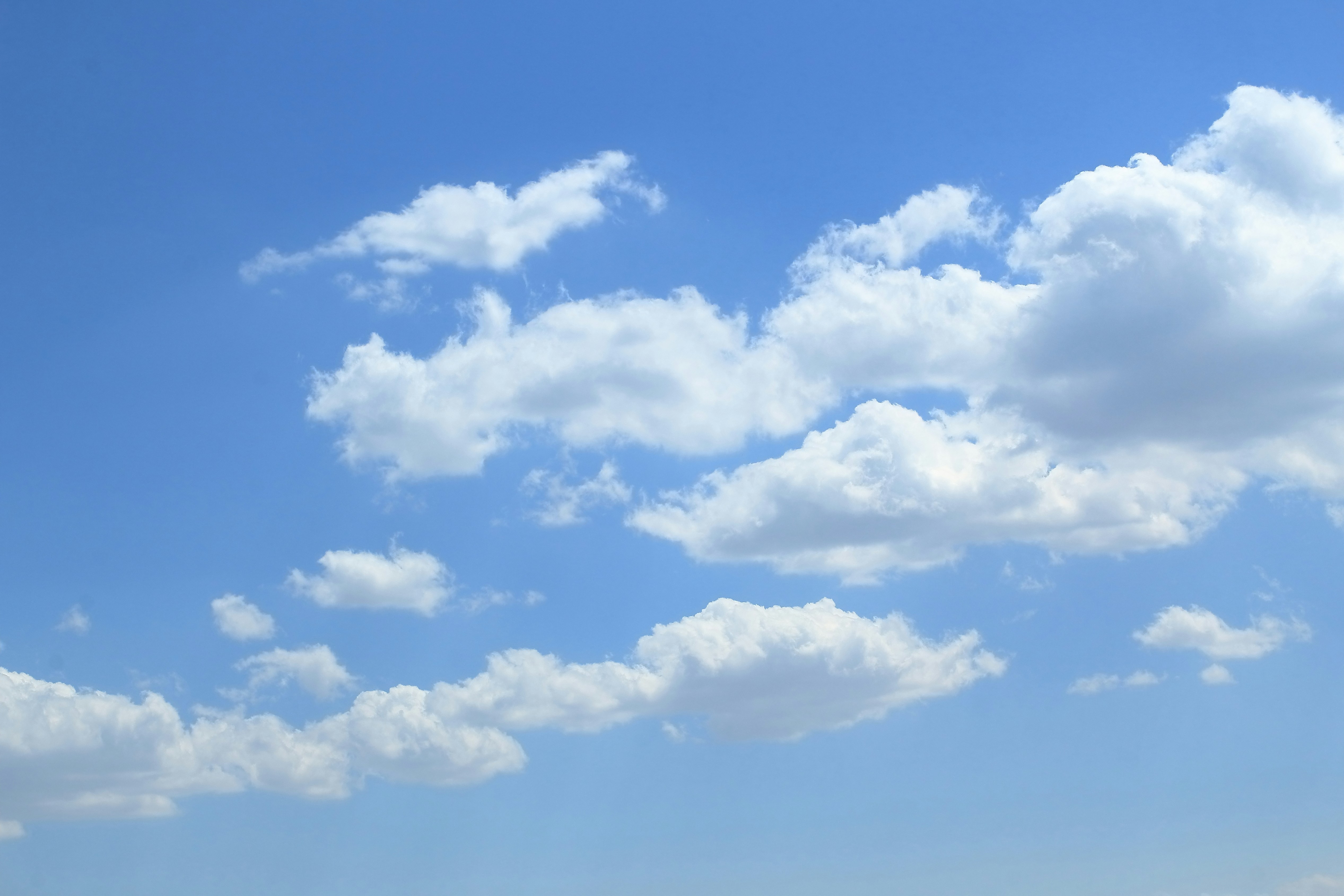 White fluffy clouds float in a bright blue sky.