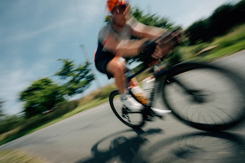 Cyclist rides fast on a curved road.