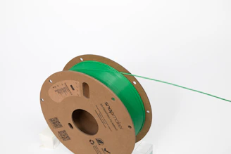 A green filament spool ready for 3D printing.