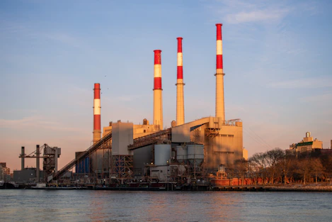 A power plant stands beside a river.