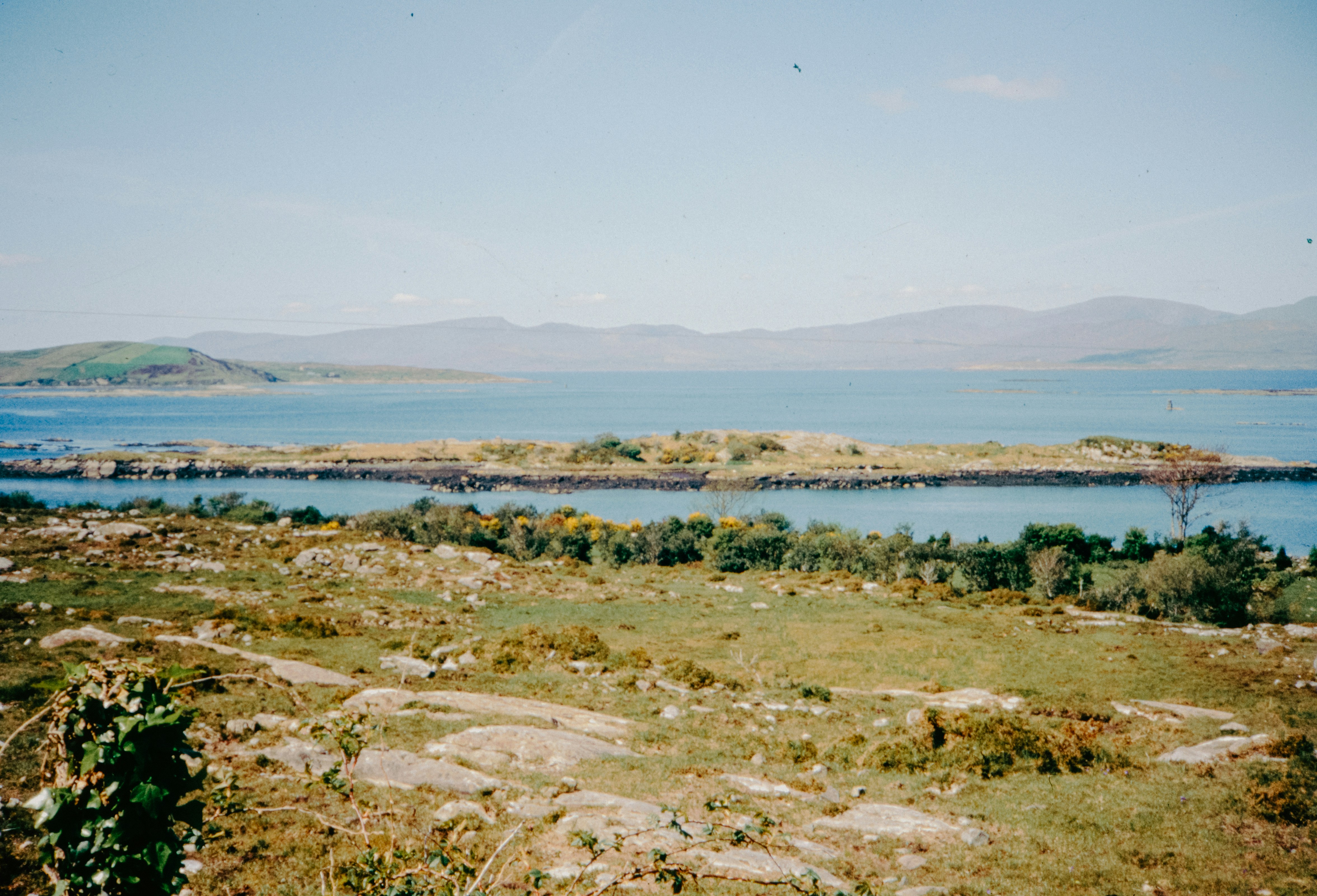 An island sits in the calm blue water.