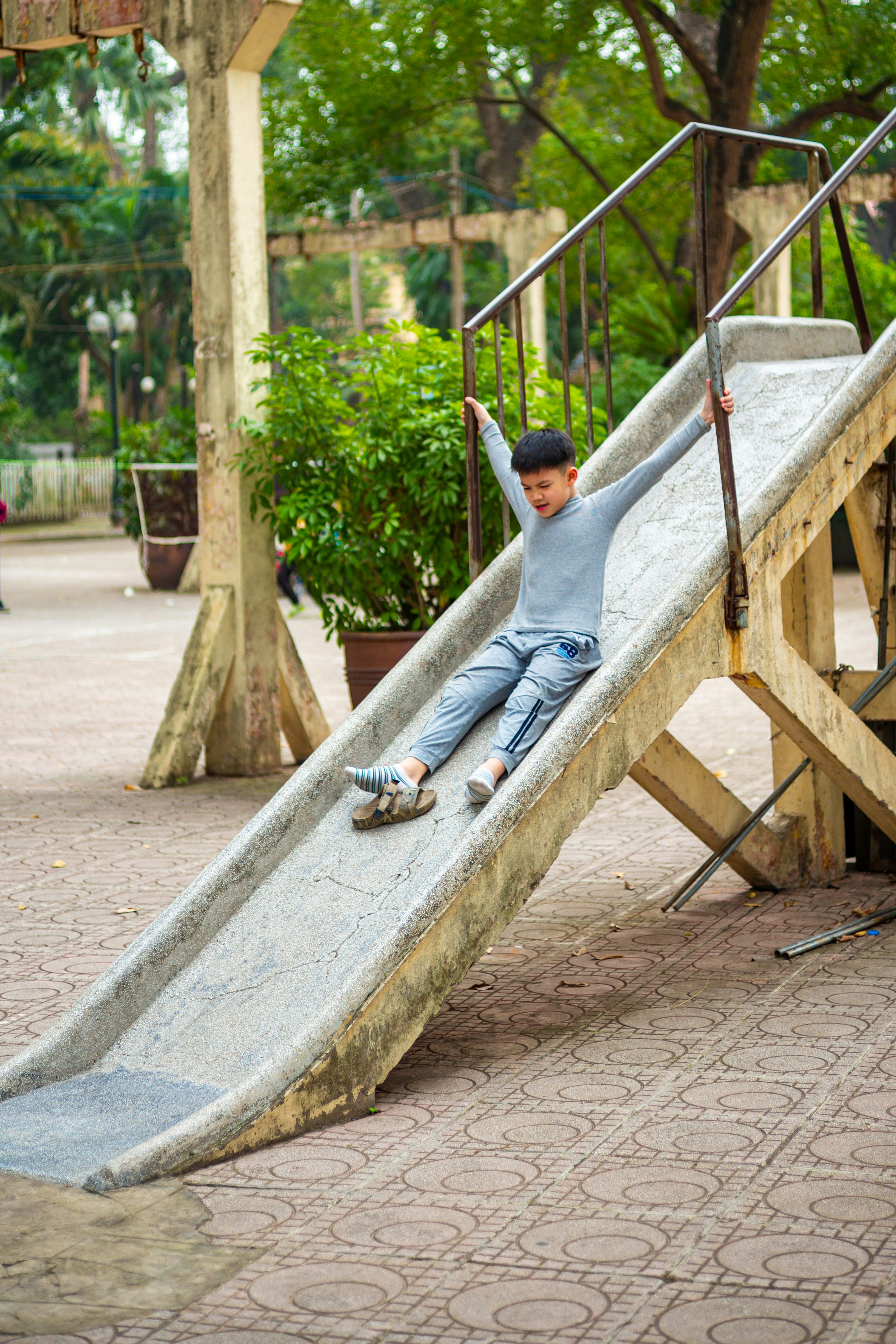 A boy slides down an outdoor playground slide.