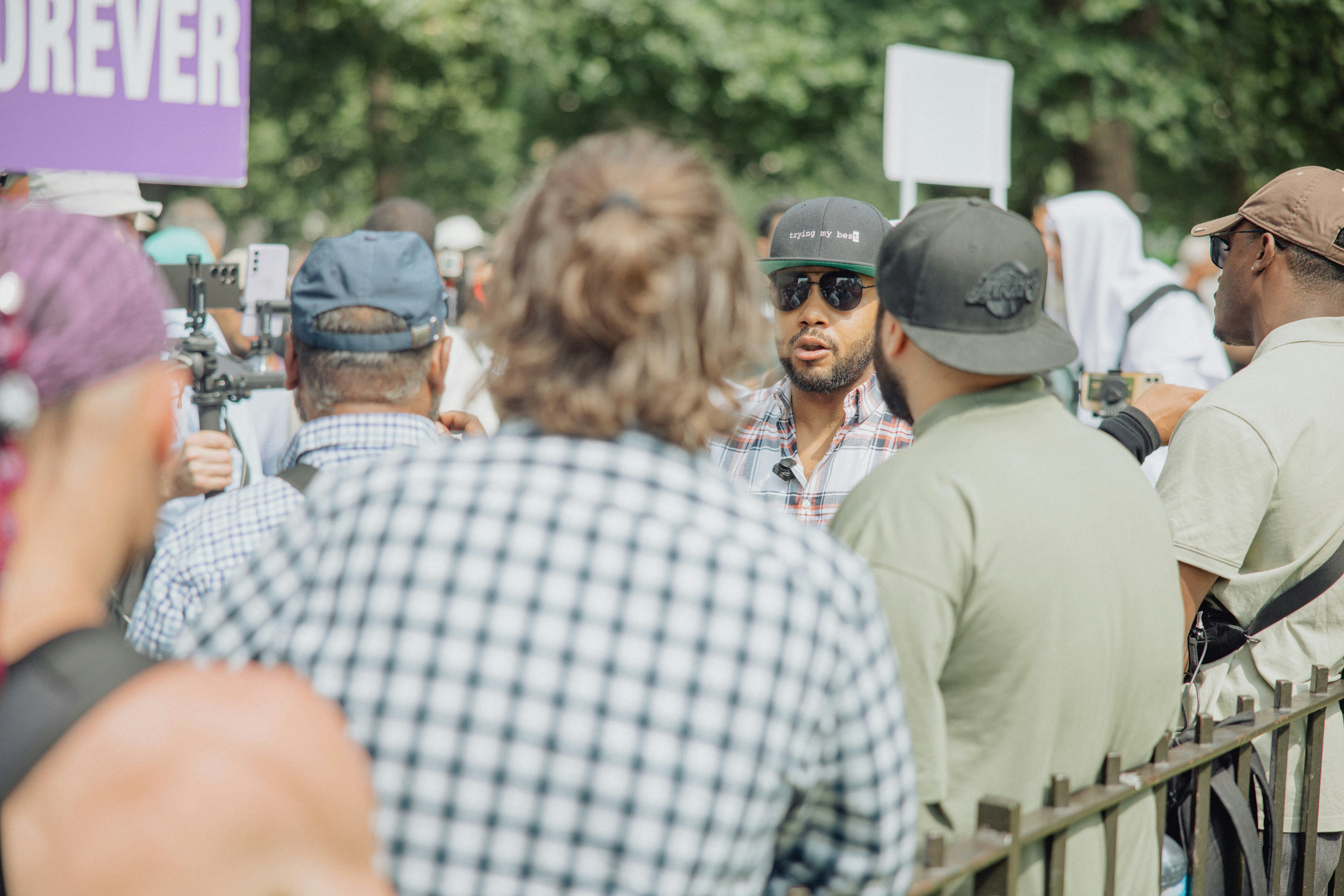 A close-up shot of small, clear crystal-like substances (crystal meth) on a black surface, with a blurred background.