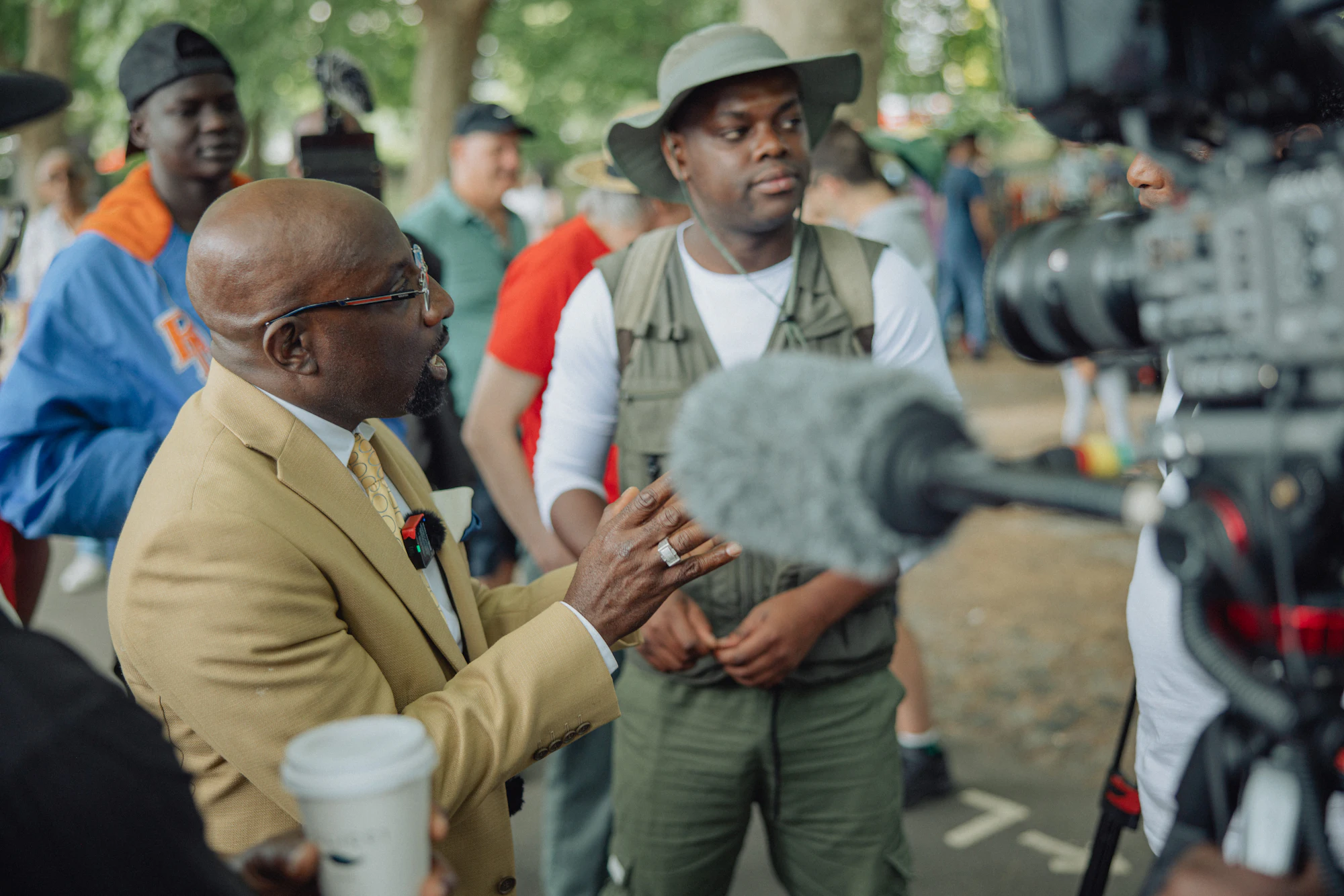A man being interviewed outdoors, surrounded by reporters
