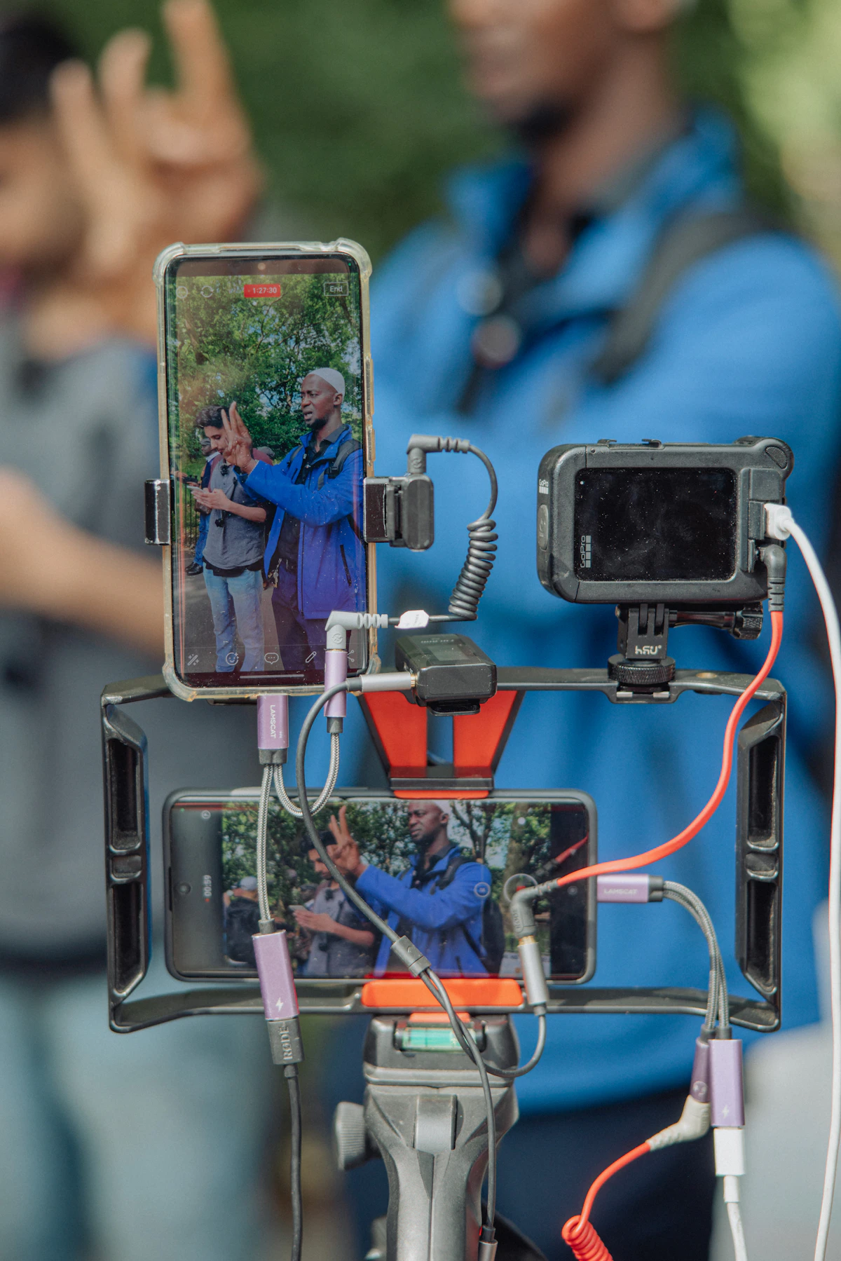 Several cameras and phones set up to record a scene