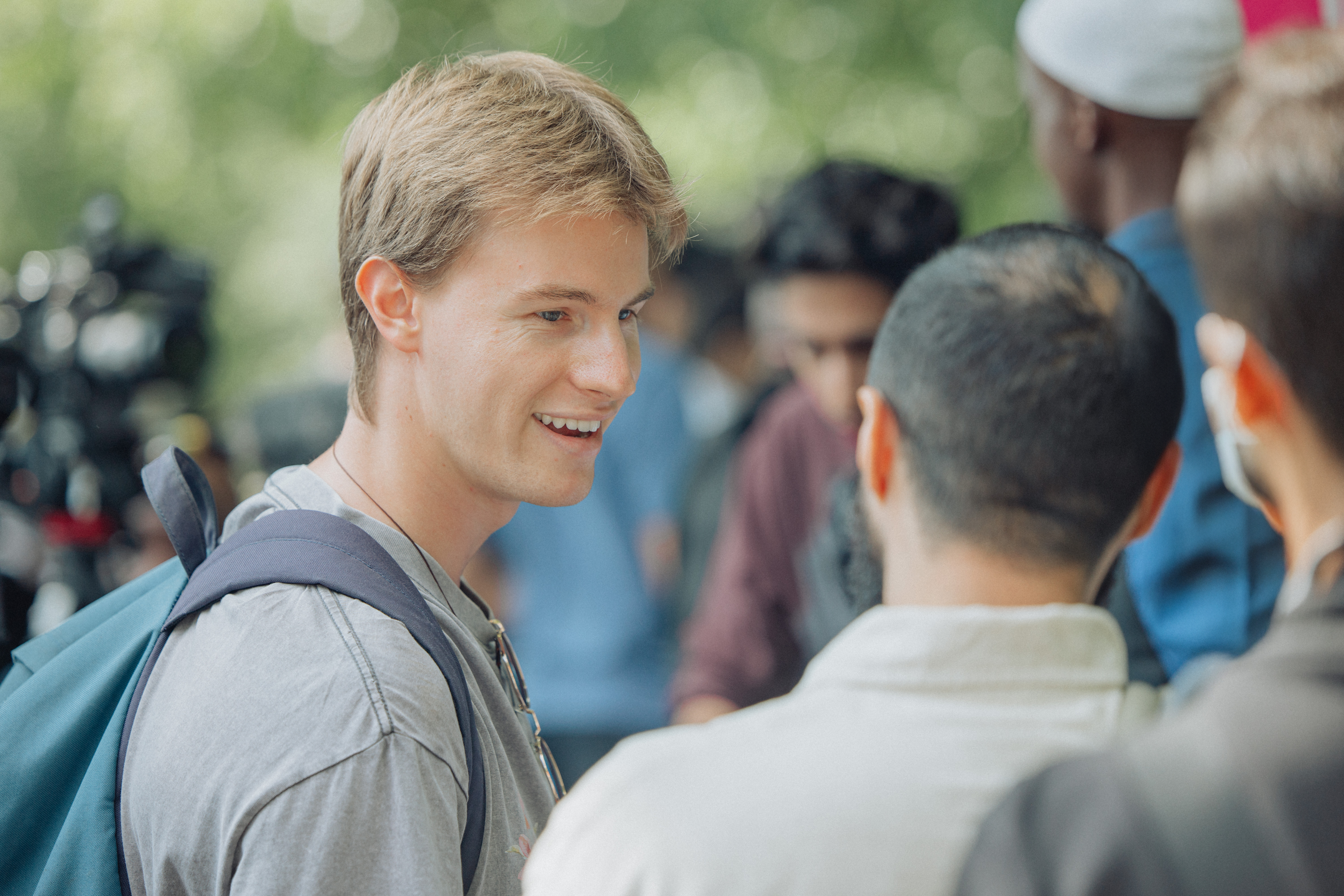 A smiling man addressing a group of people