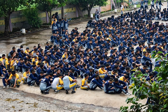 Many students are gathered outside, sitting down.