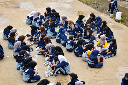 Students sit in a circle outside.