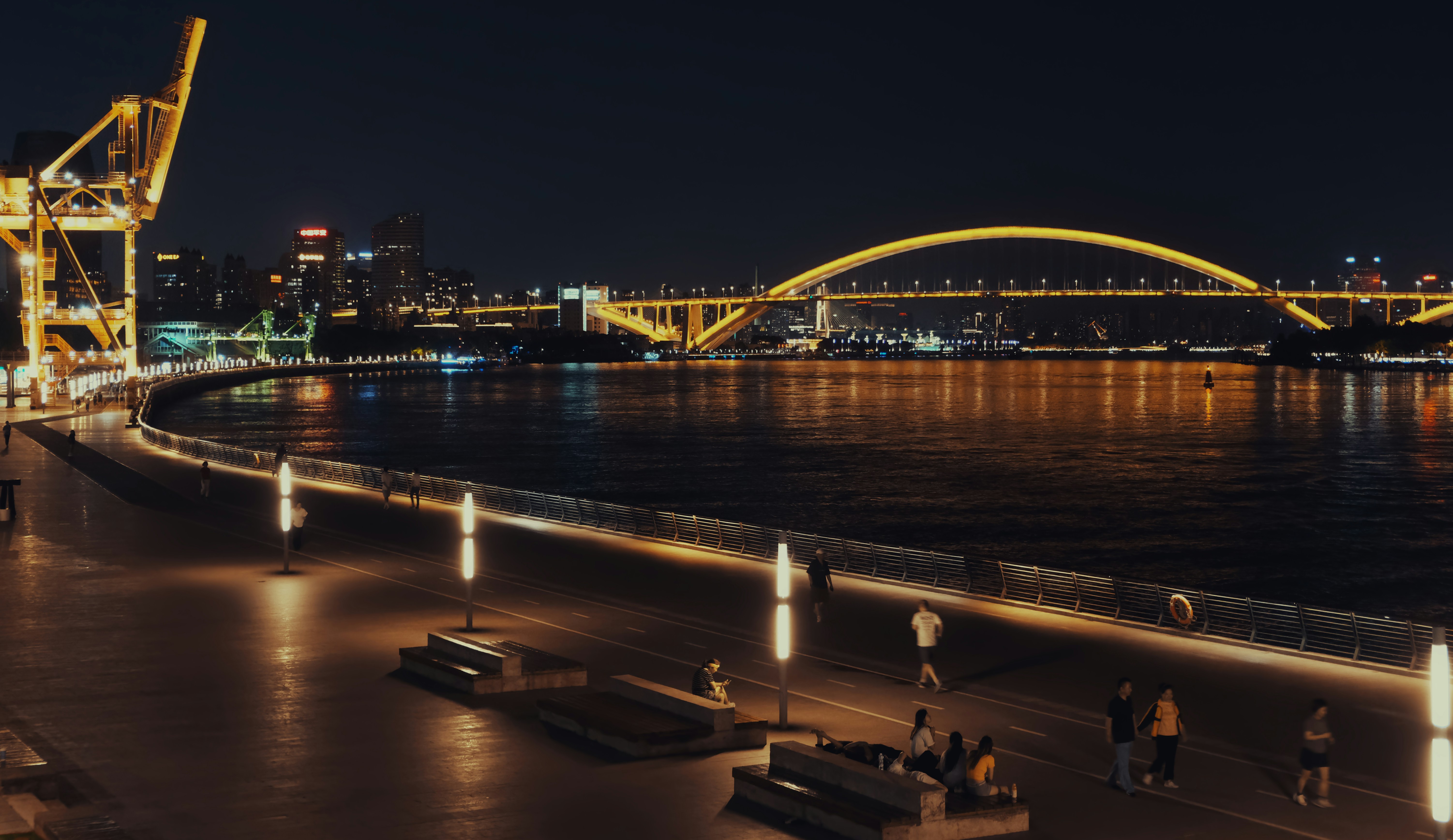 Illuminated cityscape along the river at night.