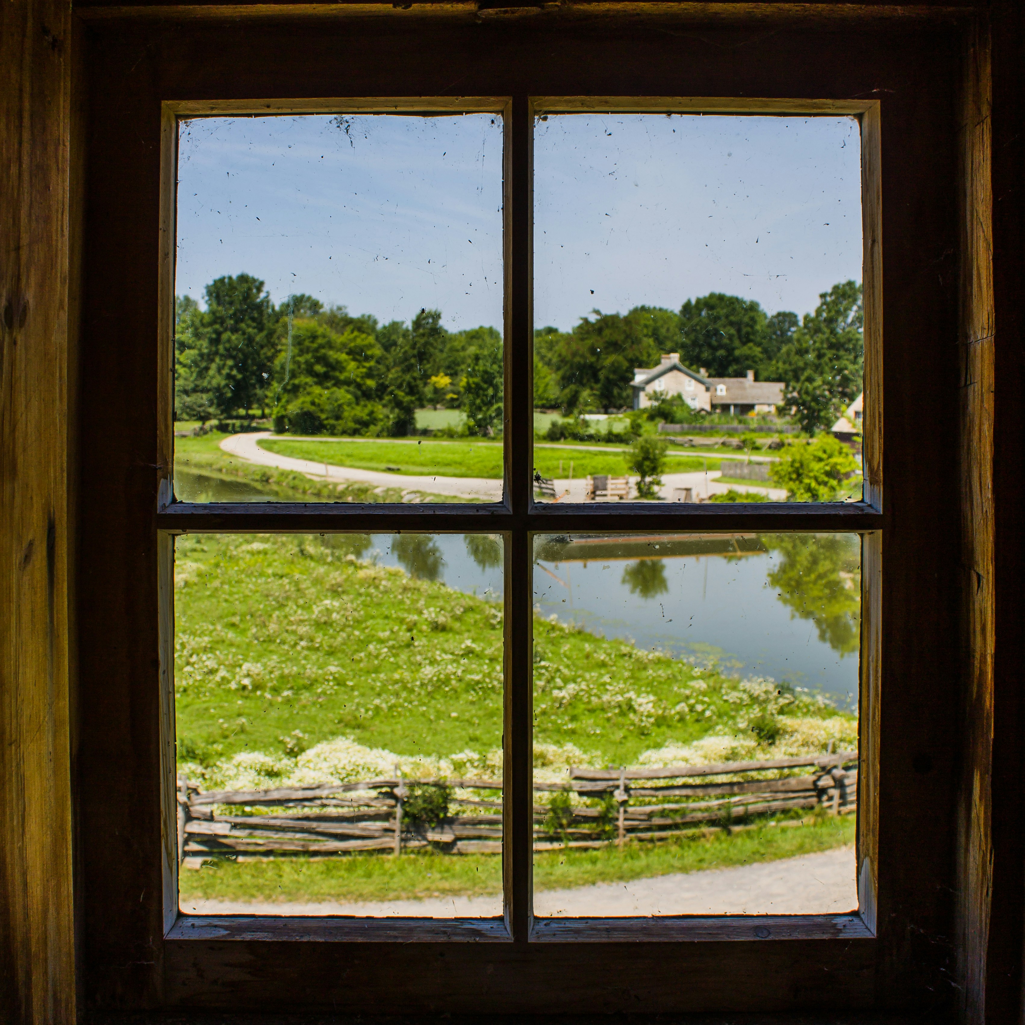 A window frames a beautiful green landscape.