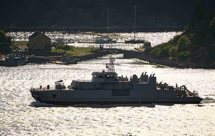 A military ship cruises through the water.
