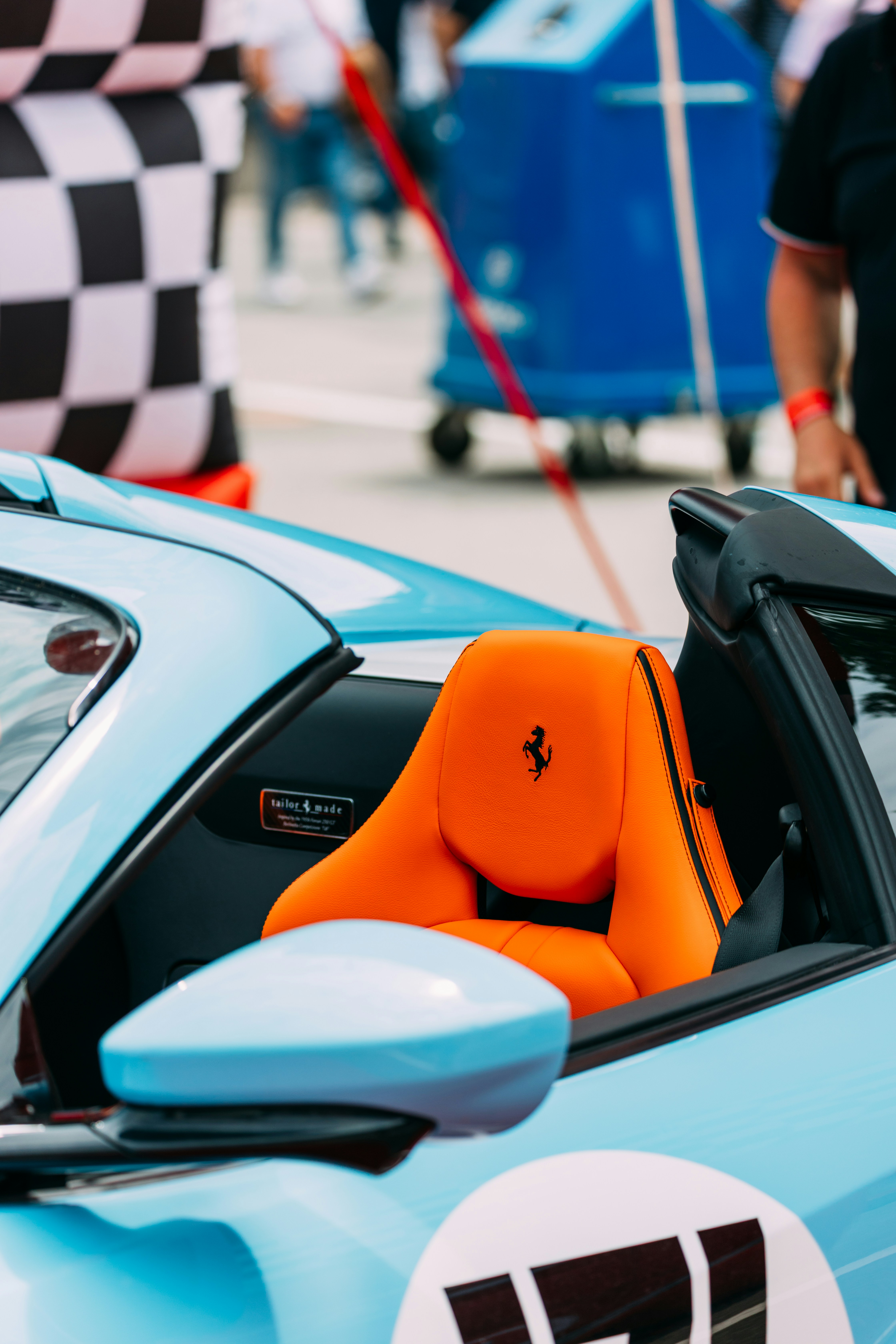Der leuchtend orangefarbene Sitz eines Ferraris in einem blauen Auto.