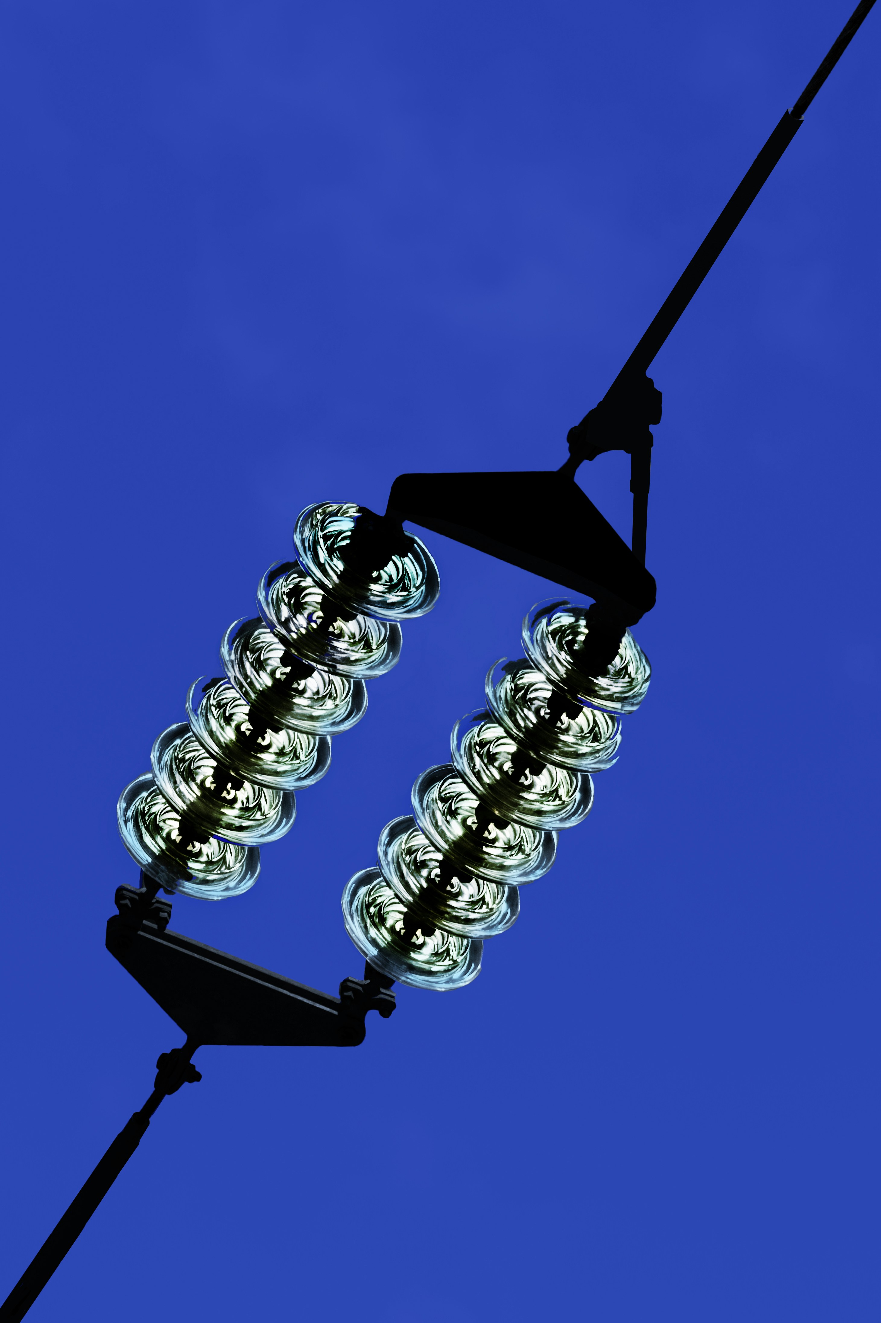 Power lines insulators against a clear blue sky.