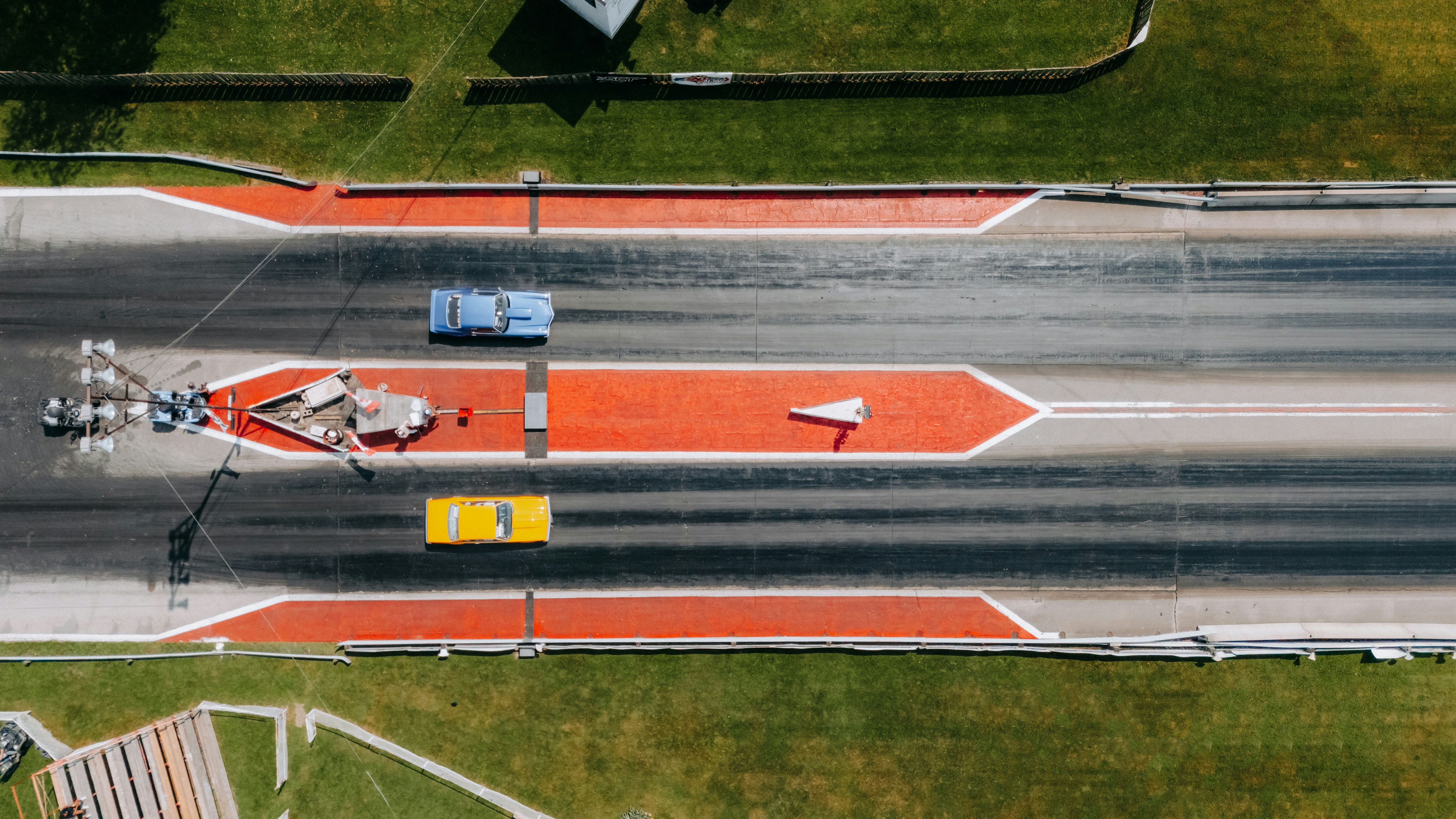 Les coureurs de dragsters dévalent la piste à toute vitesse.