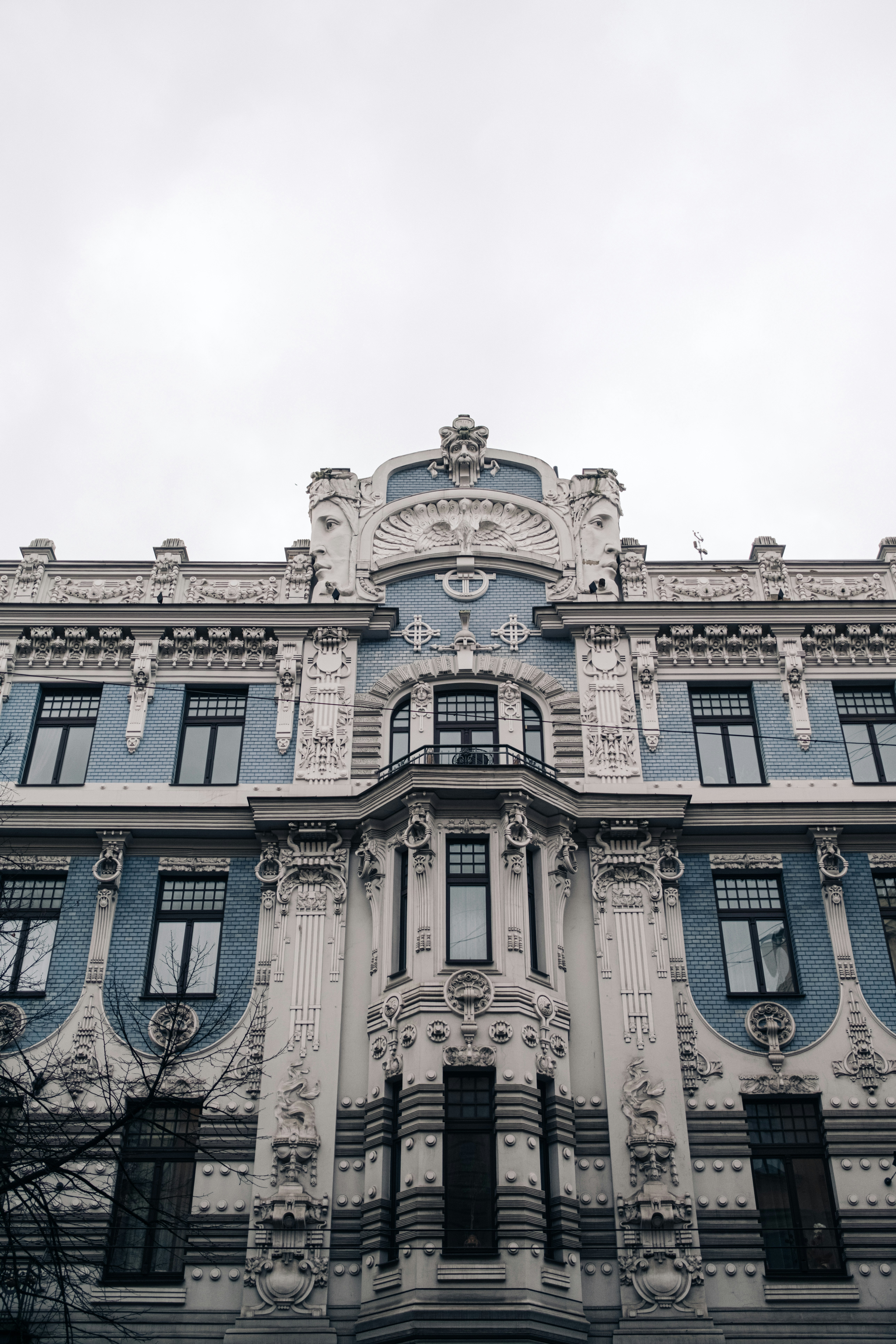 An ornate building facade beneath a cloudy sky.