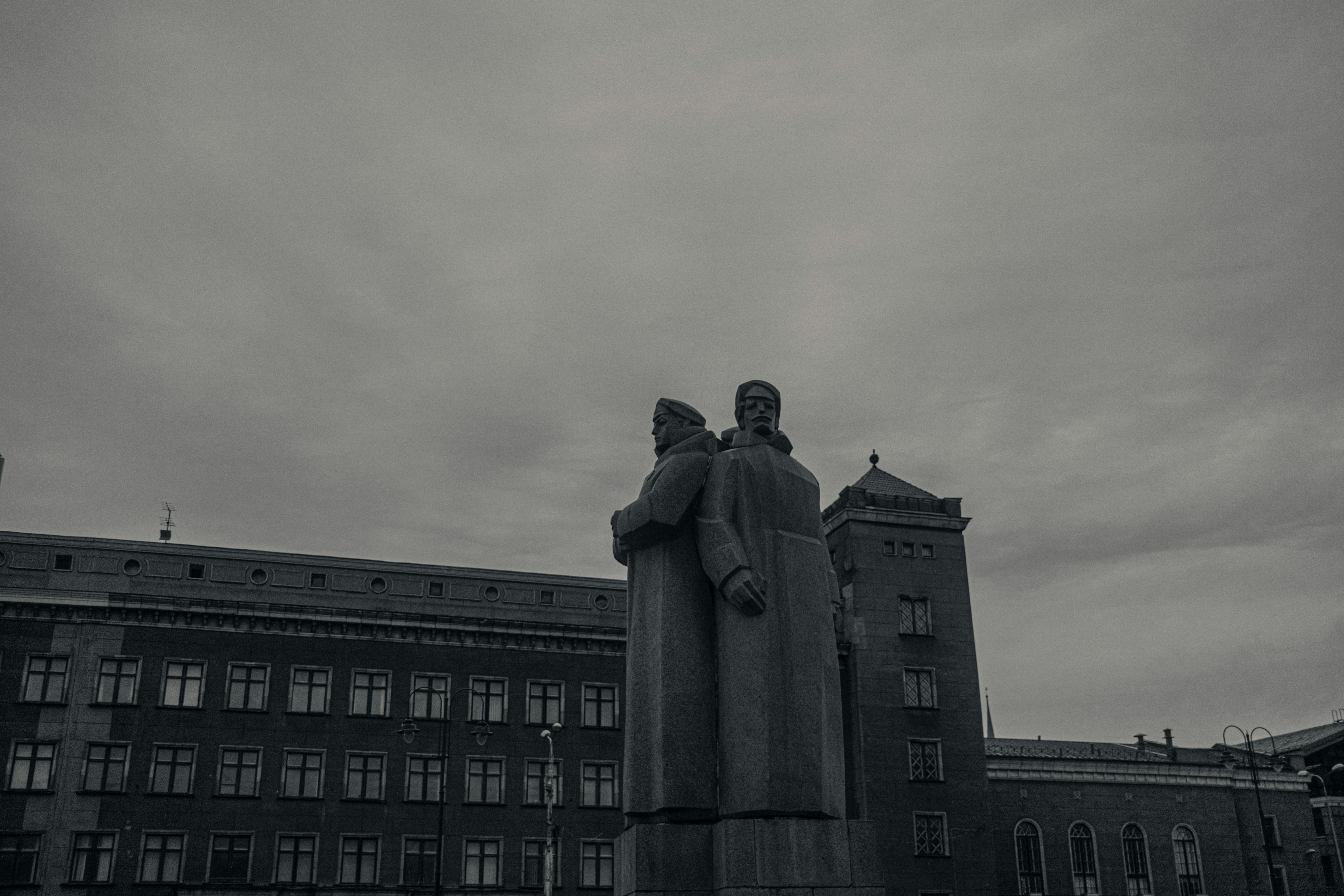 Statues of figures stand in front of a building.