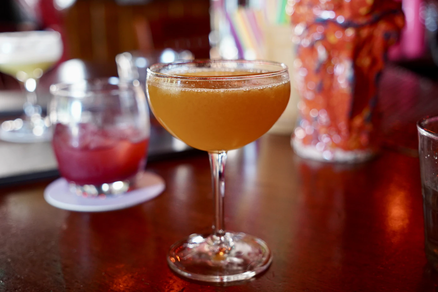 Golden cocktail in a moody bar