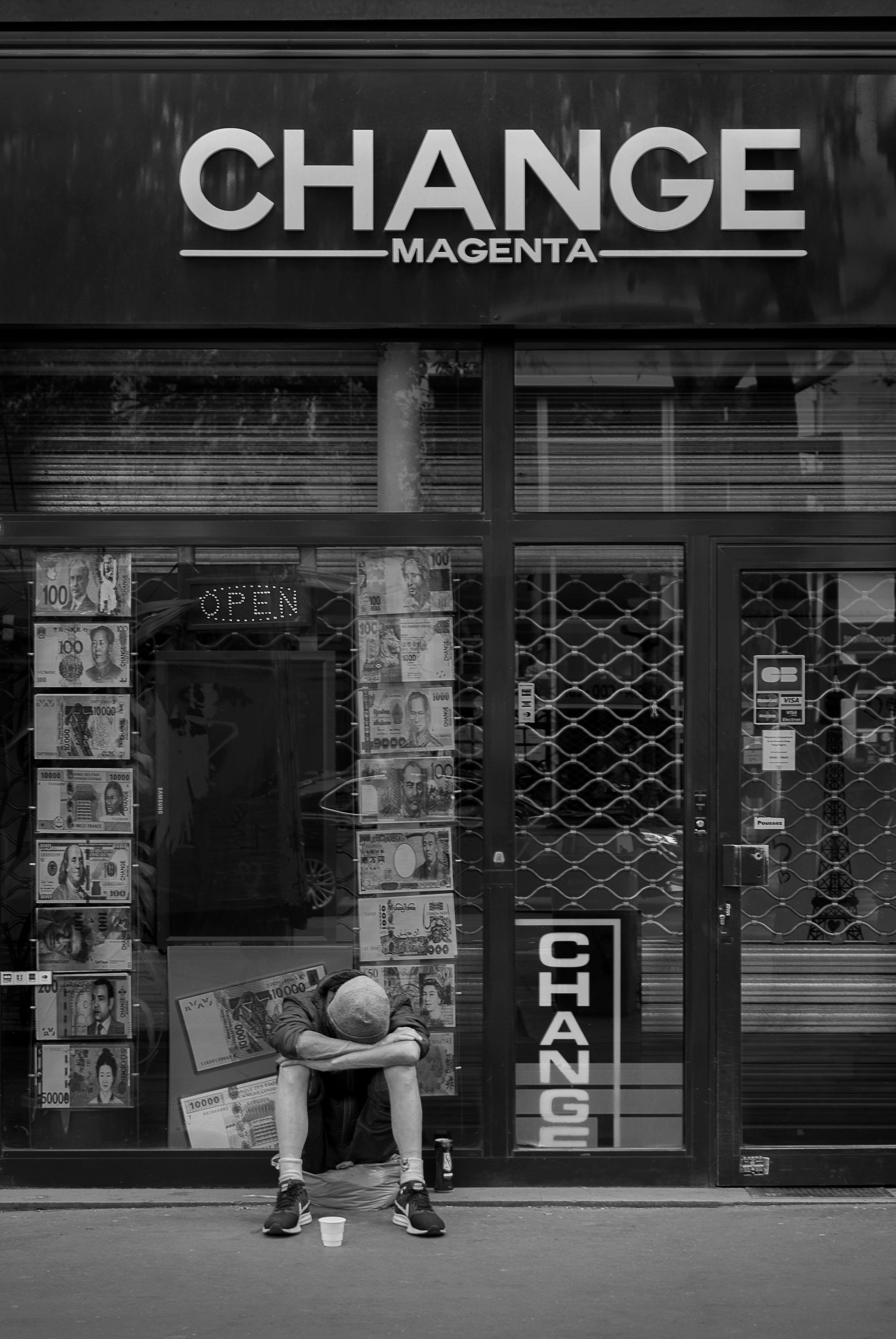 Eine traurige Person sitzt vor einer Wechselstube.