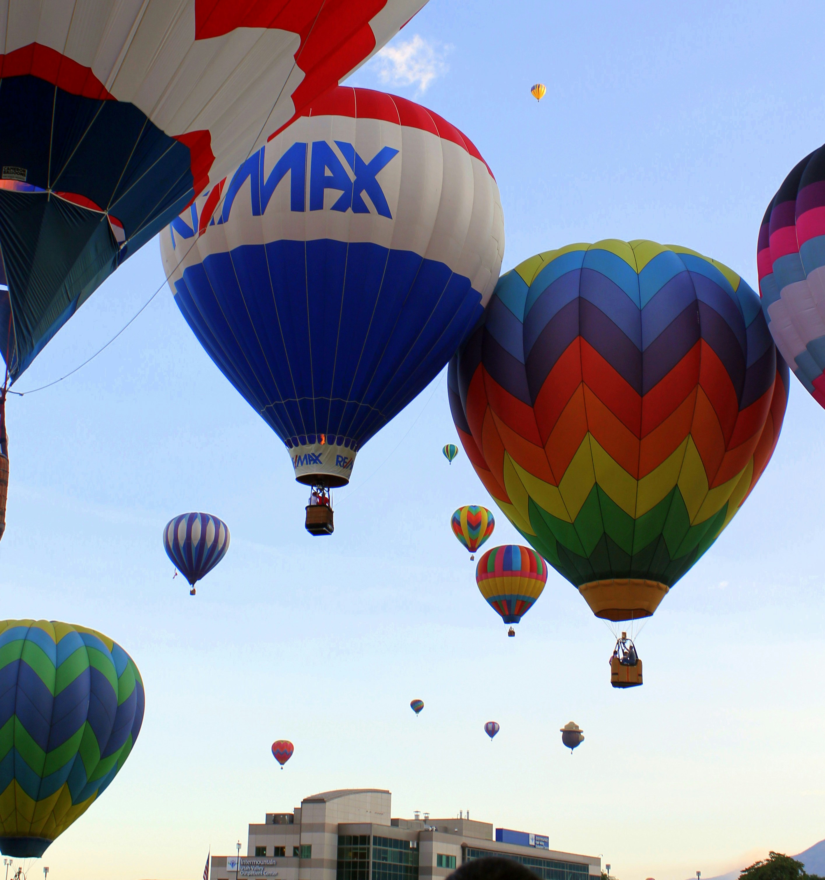 Hot air balloons soar in a vibrant sky.