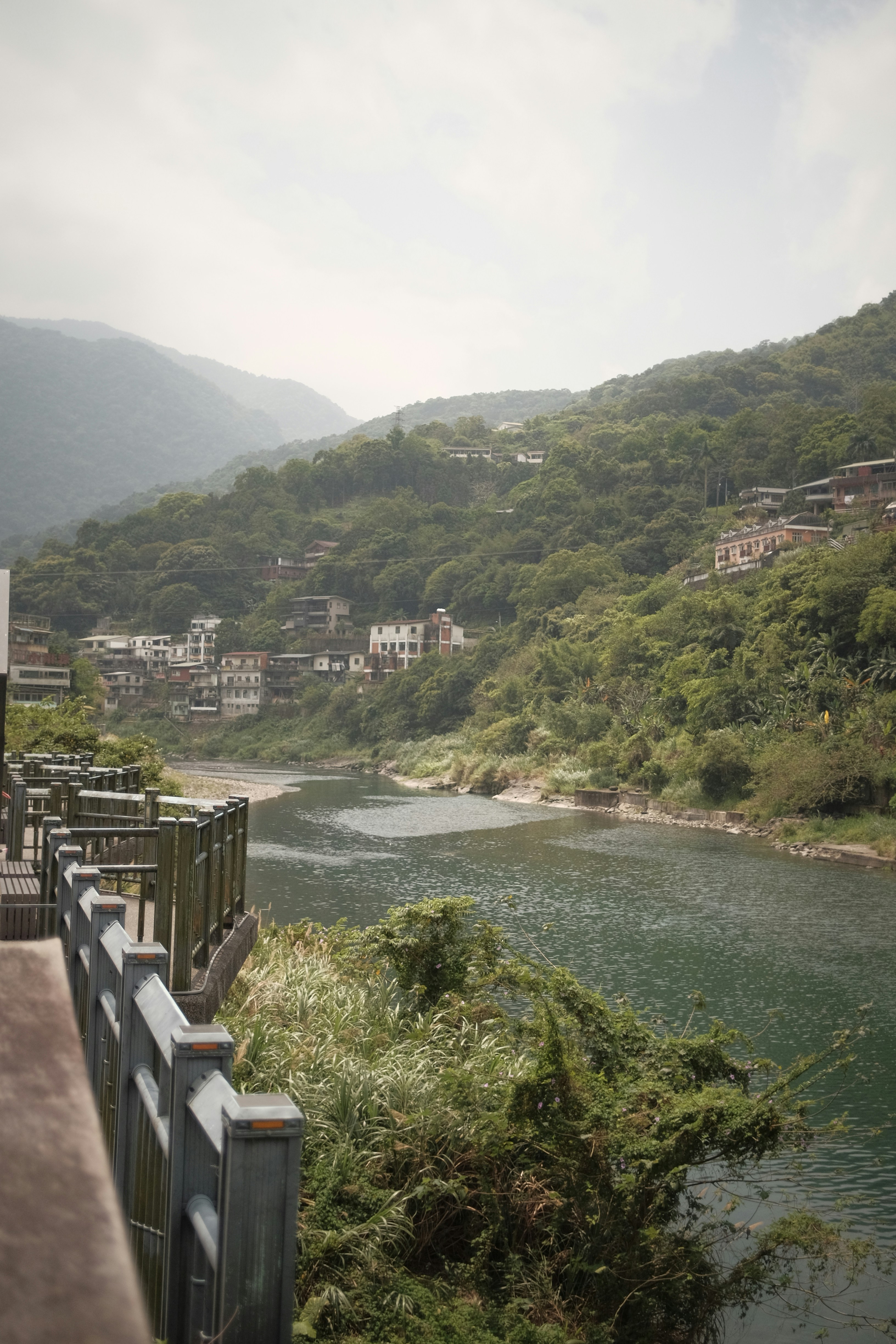 A serene river flows beside lush, green hills.