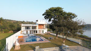 Modern house with a pool next to a lake.