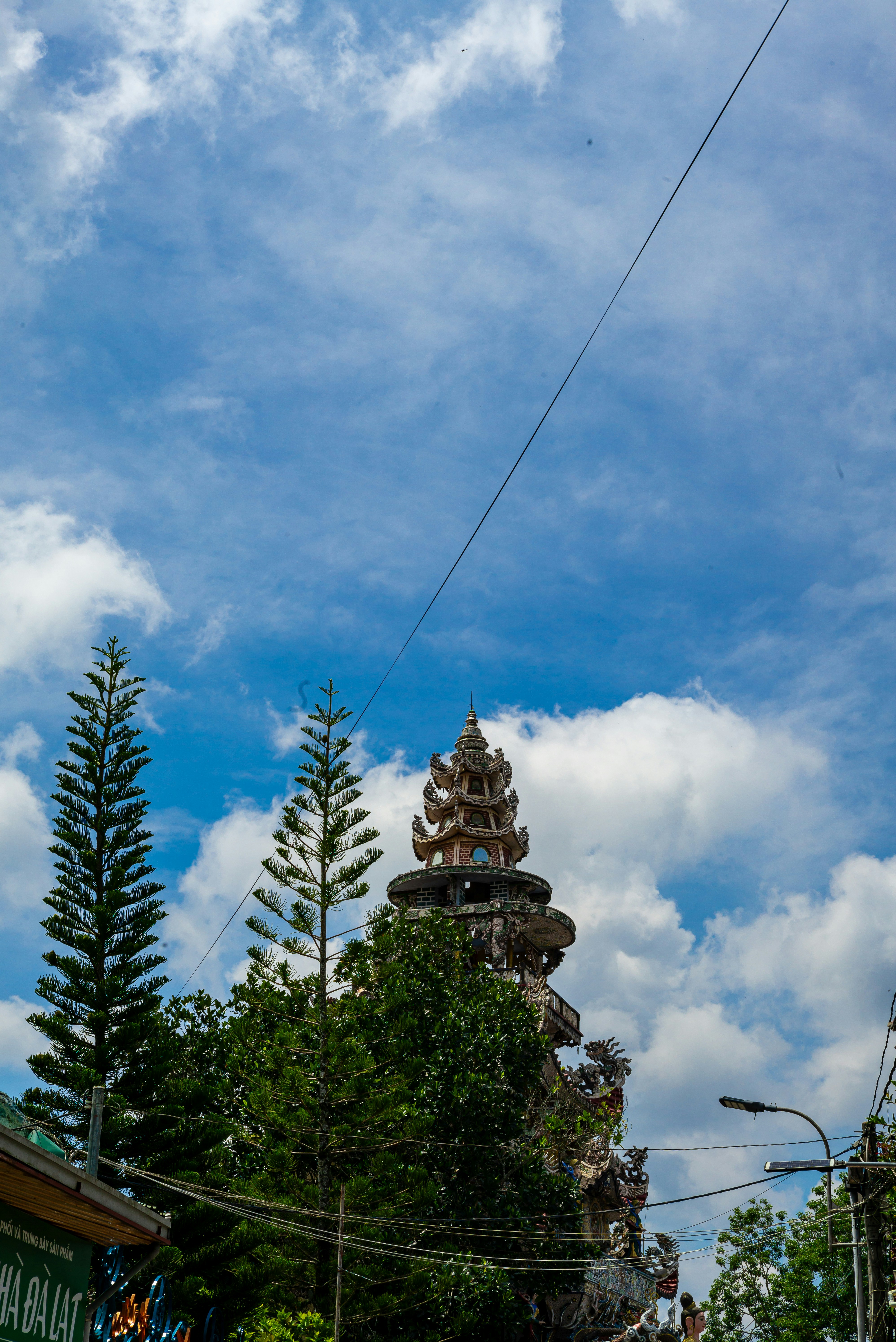 Beautiful pagoda and trees against a bright, cloudy sky.