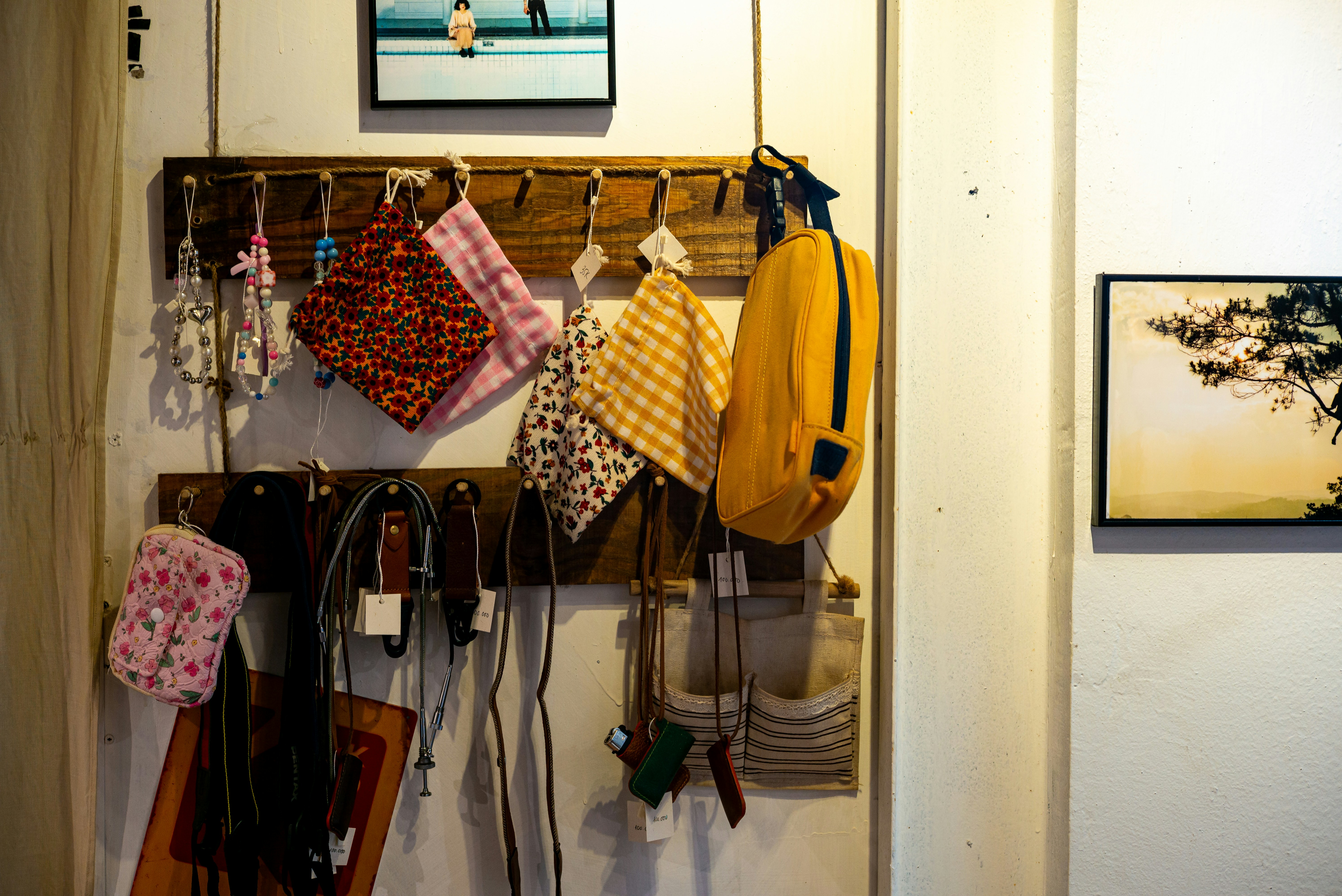 Handbags and other items hang on a wooden rack.