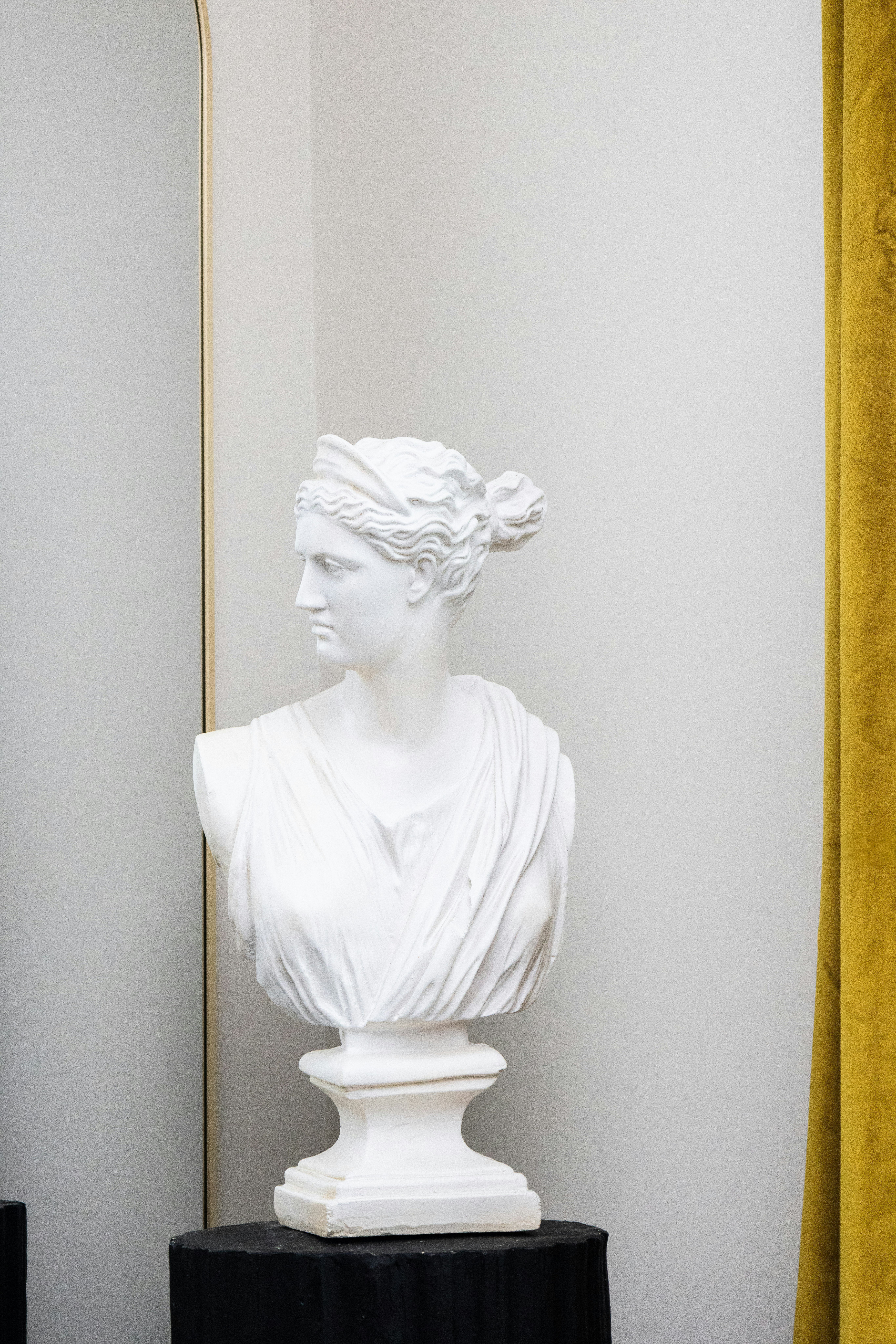 White bust of a woman stands elegantly.