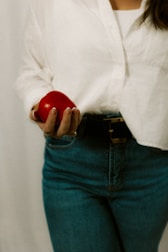 Woman holds a red apple with one hand.
