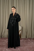 A woman models a black abaya dress.