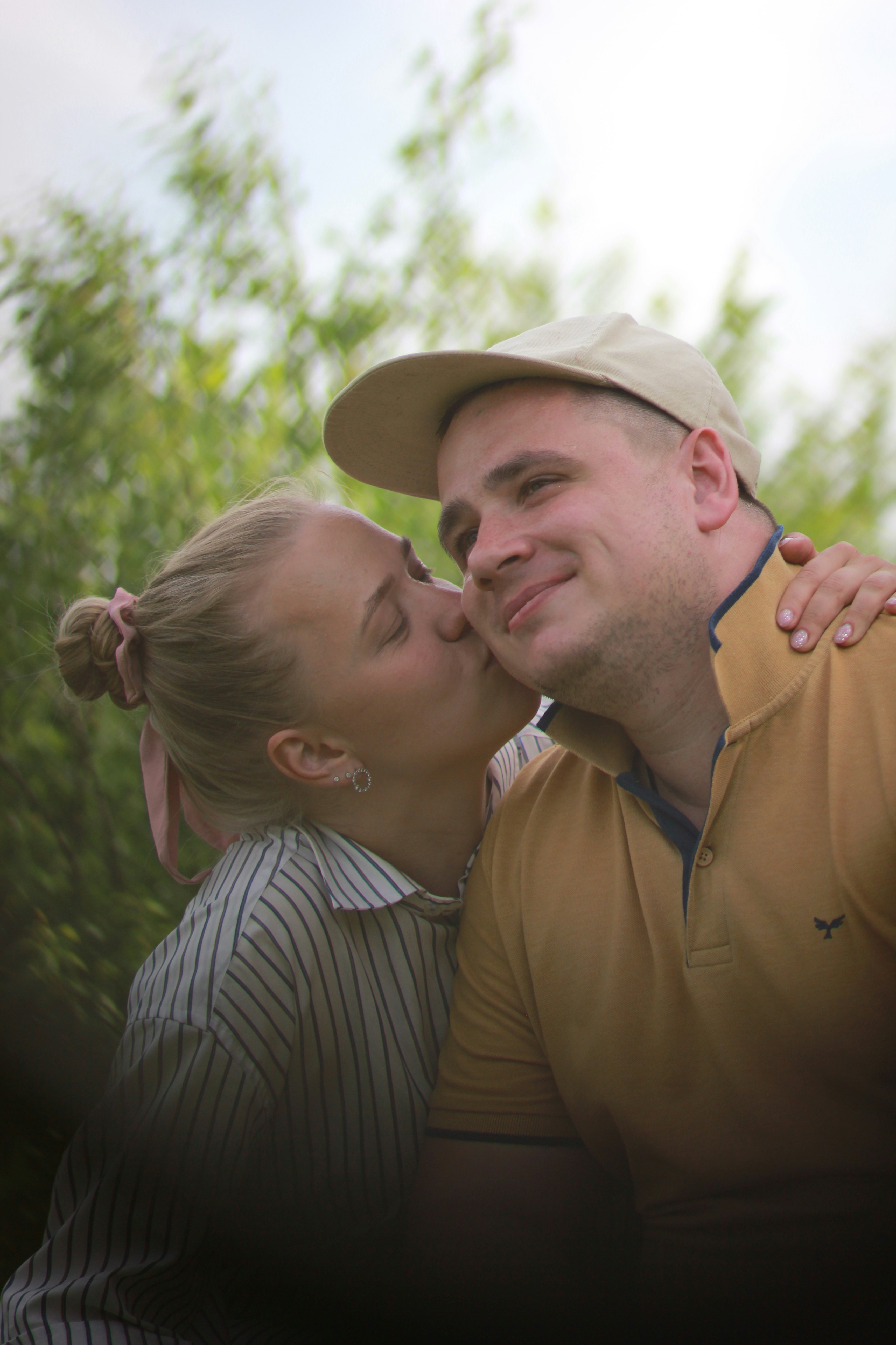 Woman kisses a man on the cheek.
