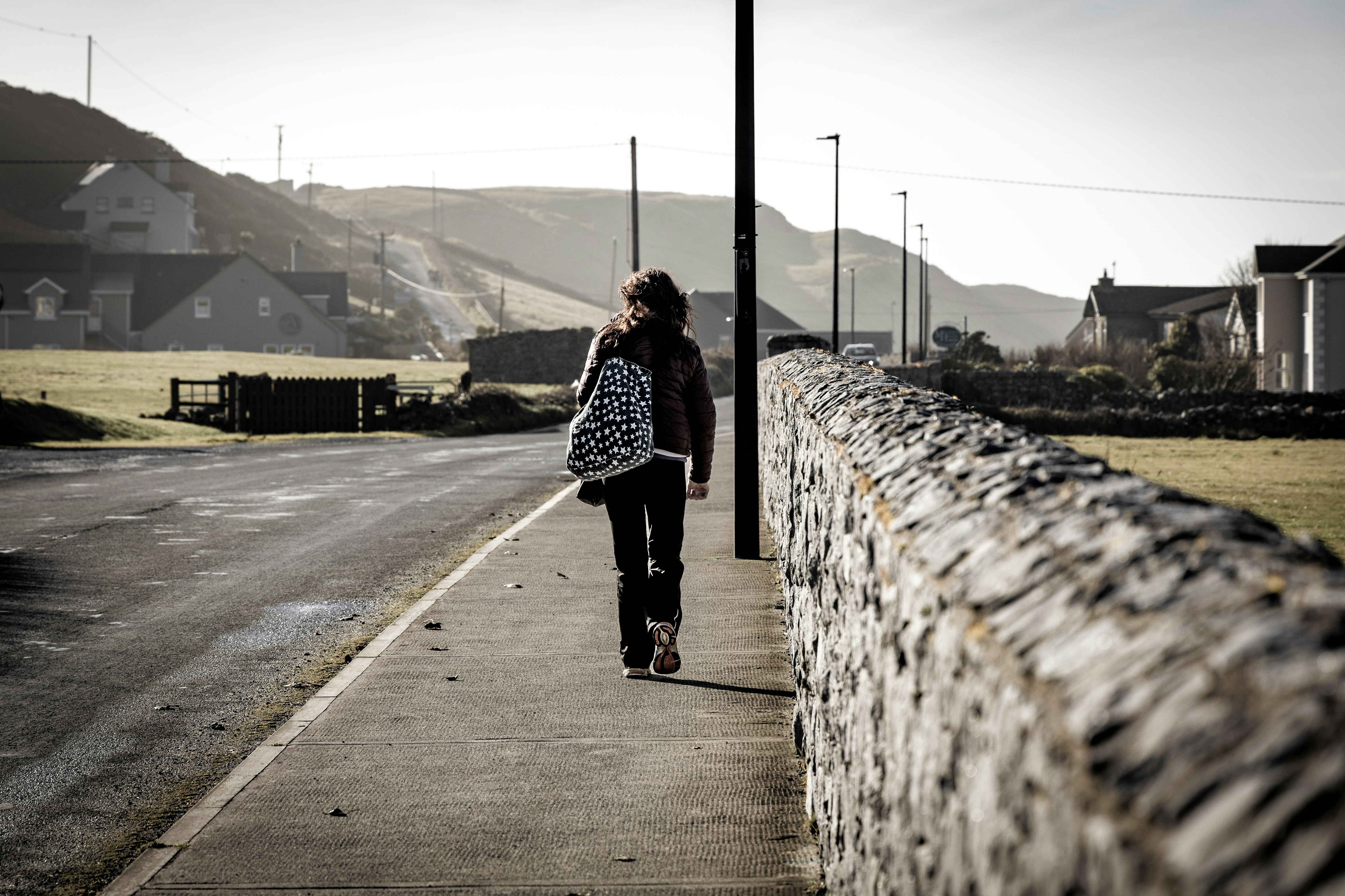 A person walks along a quiet road.