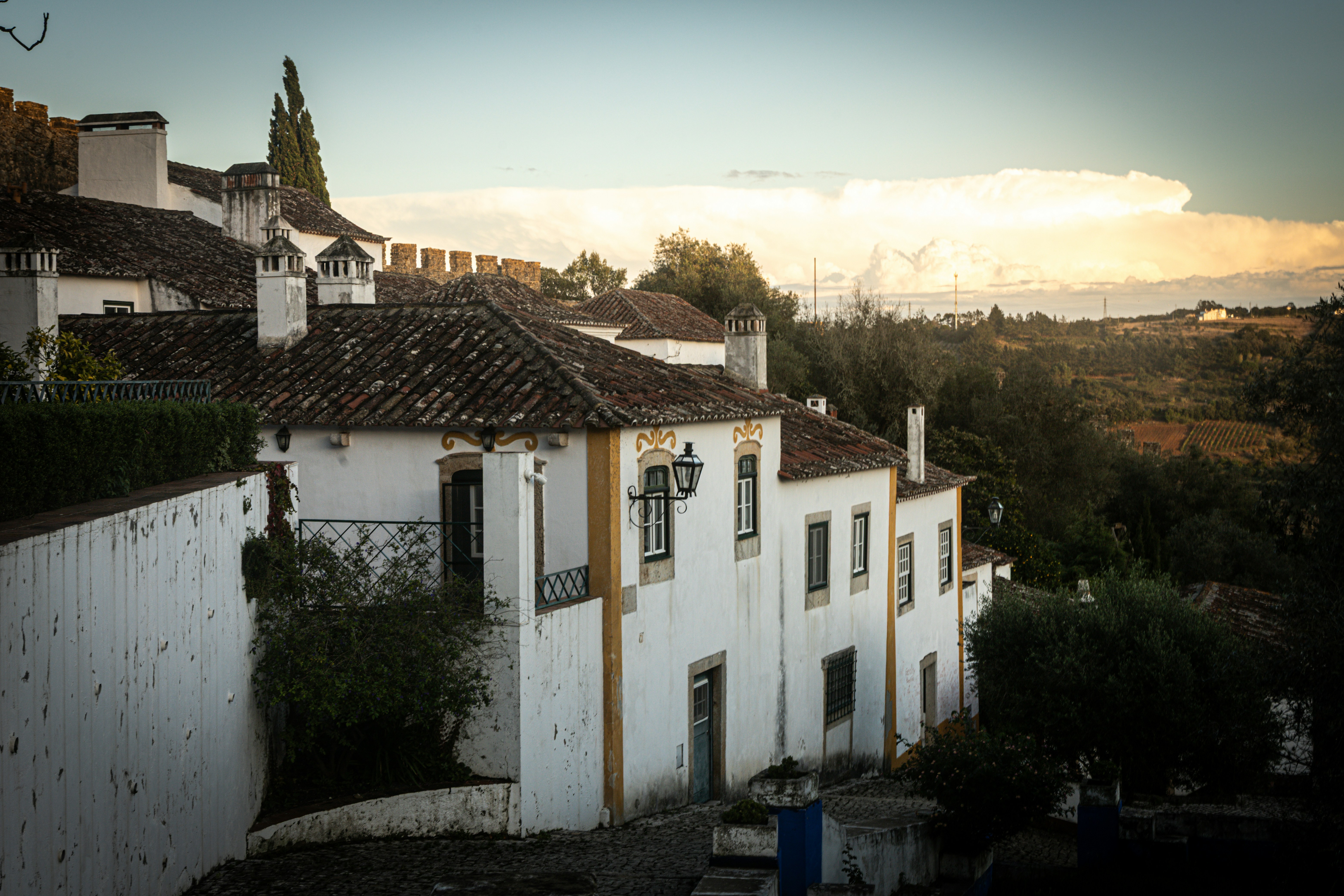 Old white buildings sit on a hillside.