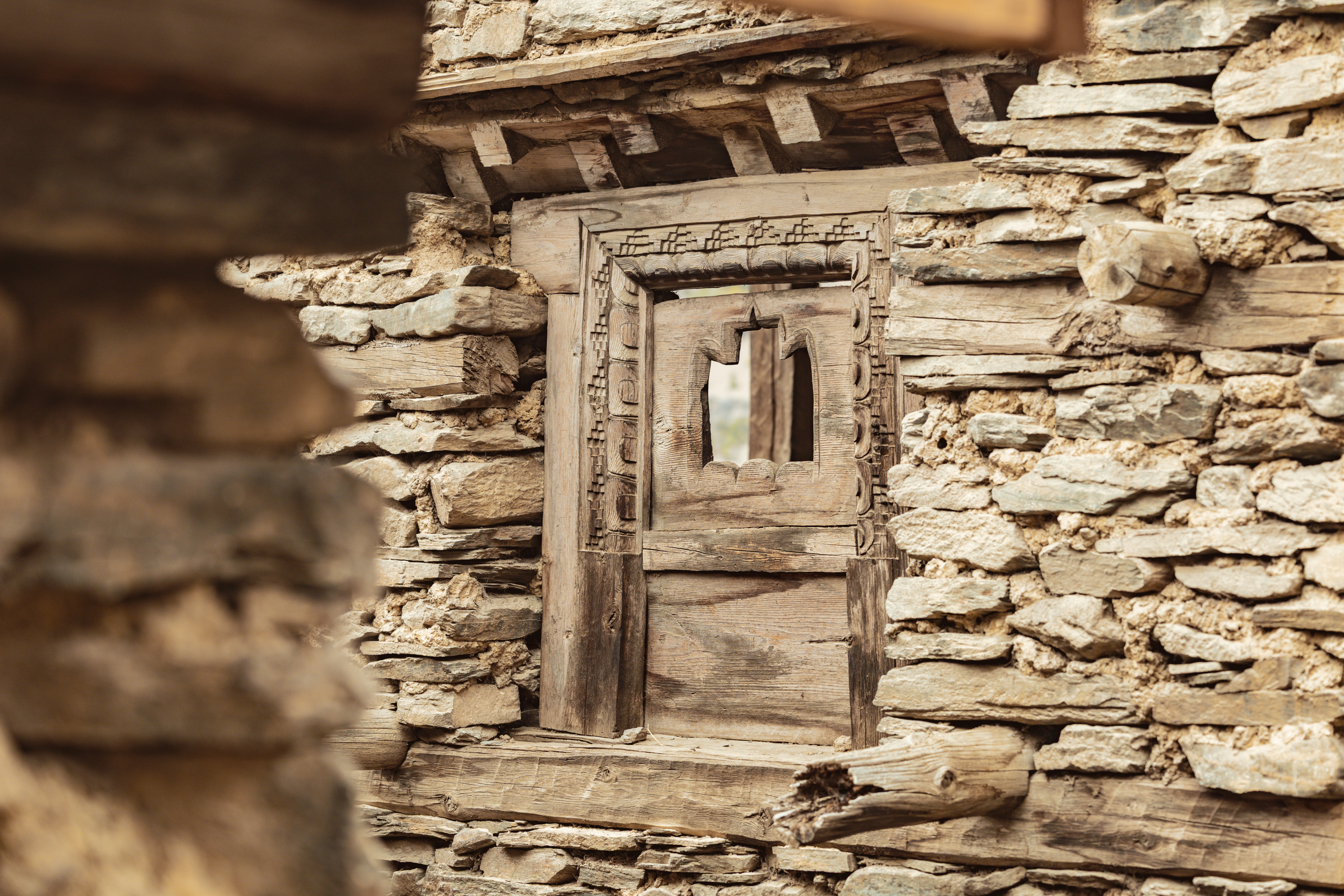 Old, weathered window set into a stone wall.