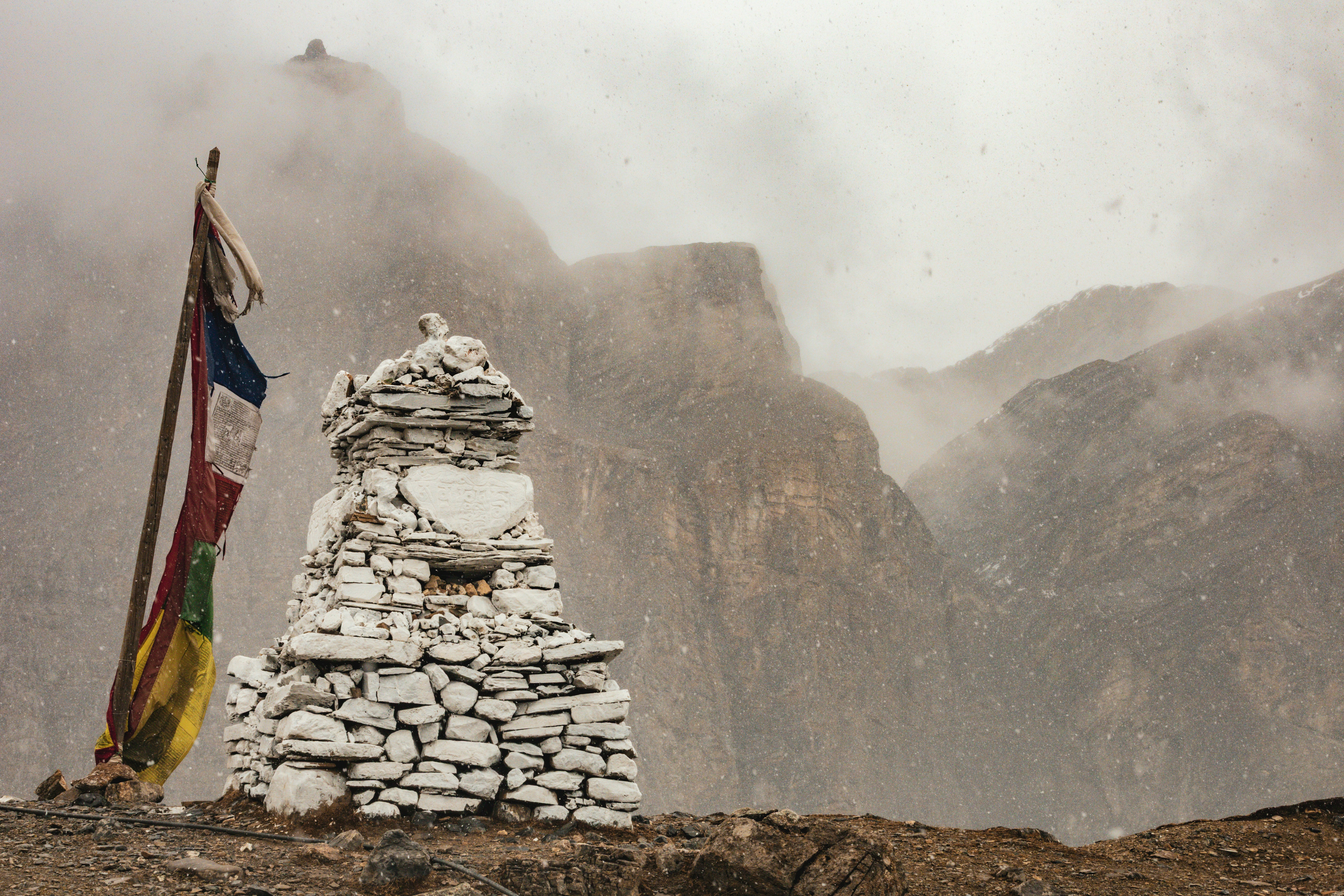 Prayer flags and stupa in a misty mountain scene.