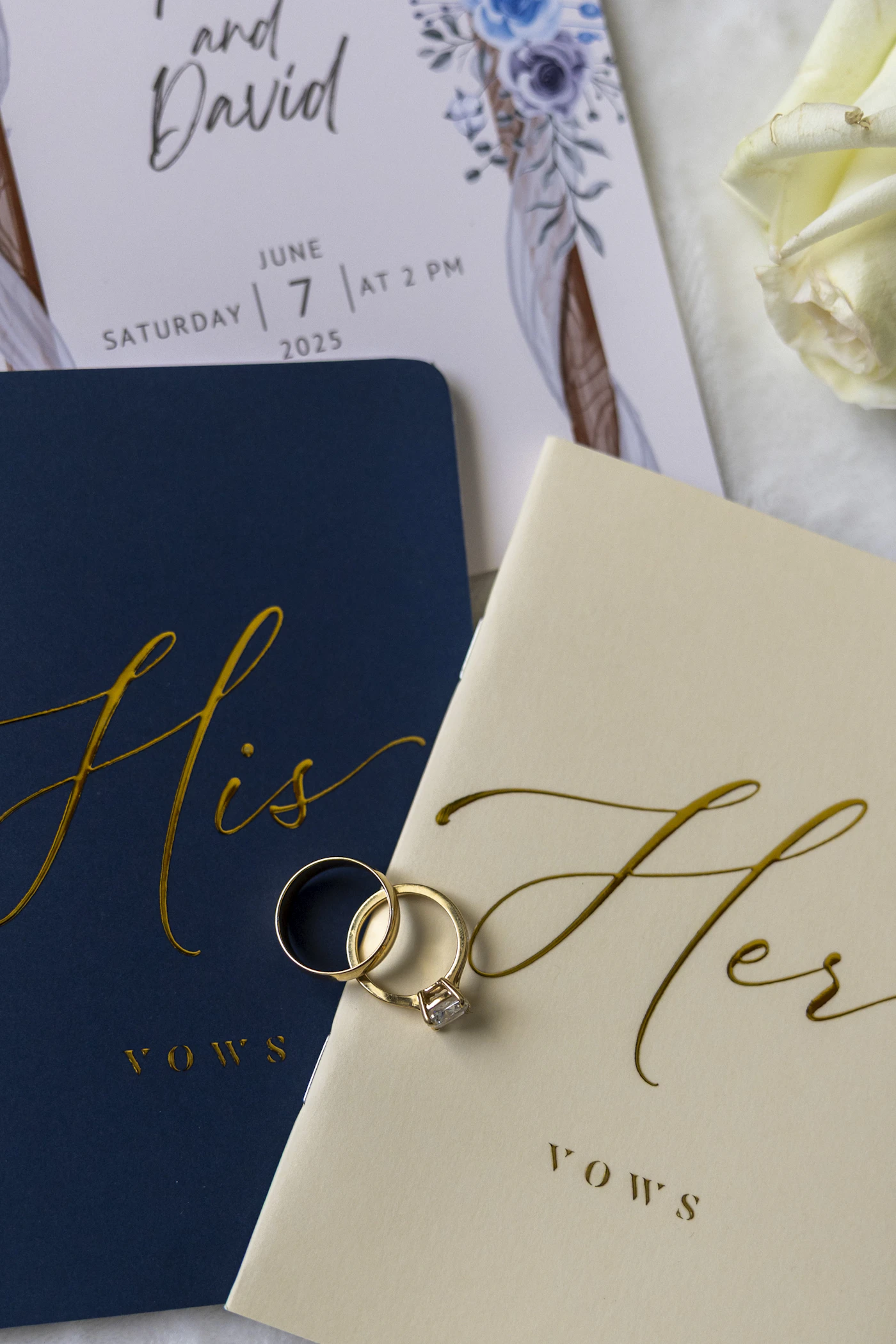 Wedding rings resting on his and hers vow books
