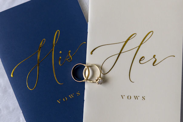 Wedding rings rest on "his" and "her" vow books