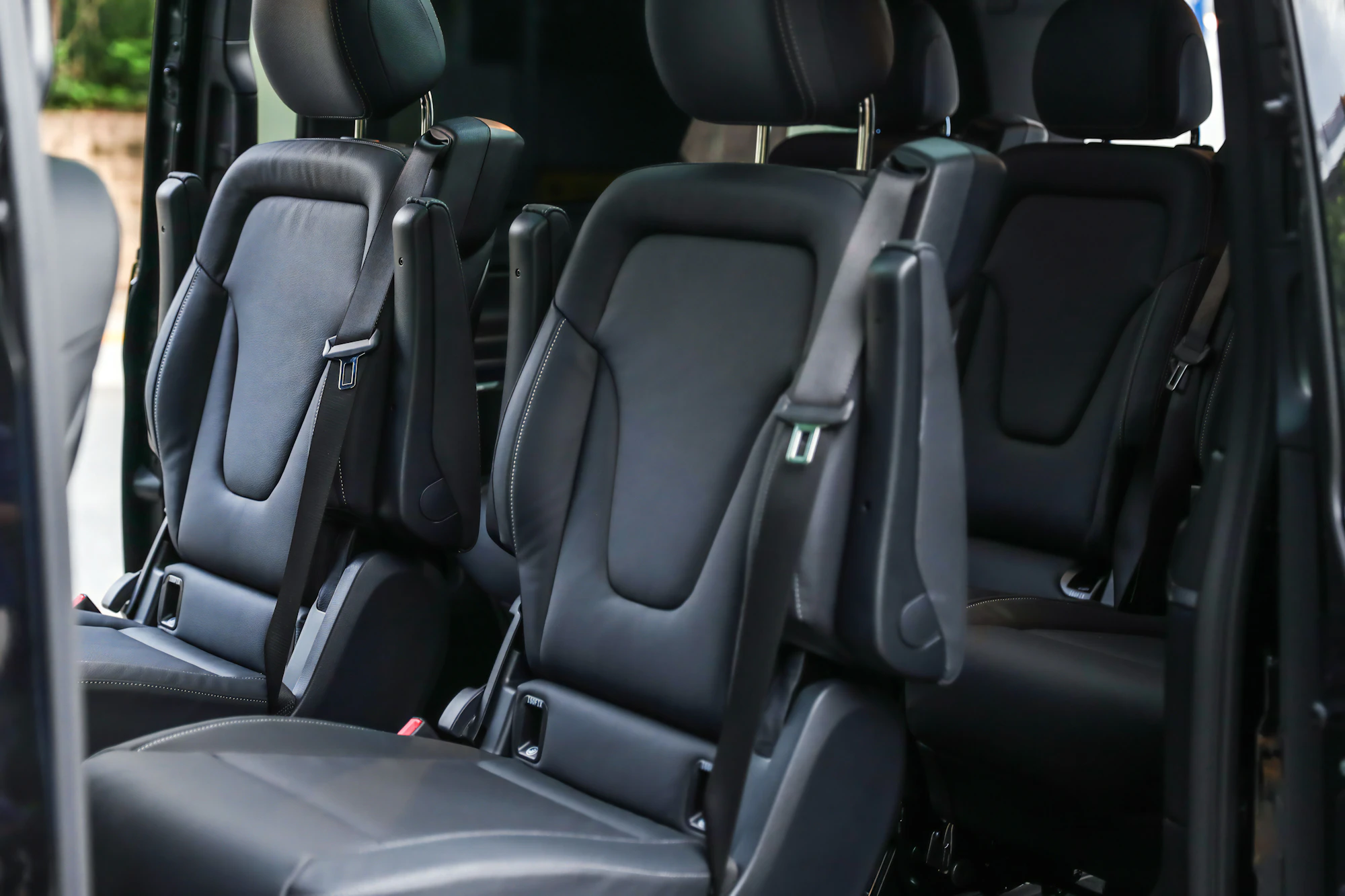 Black leather lounge seating inside a Limo Sprinter