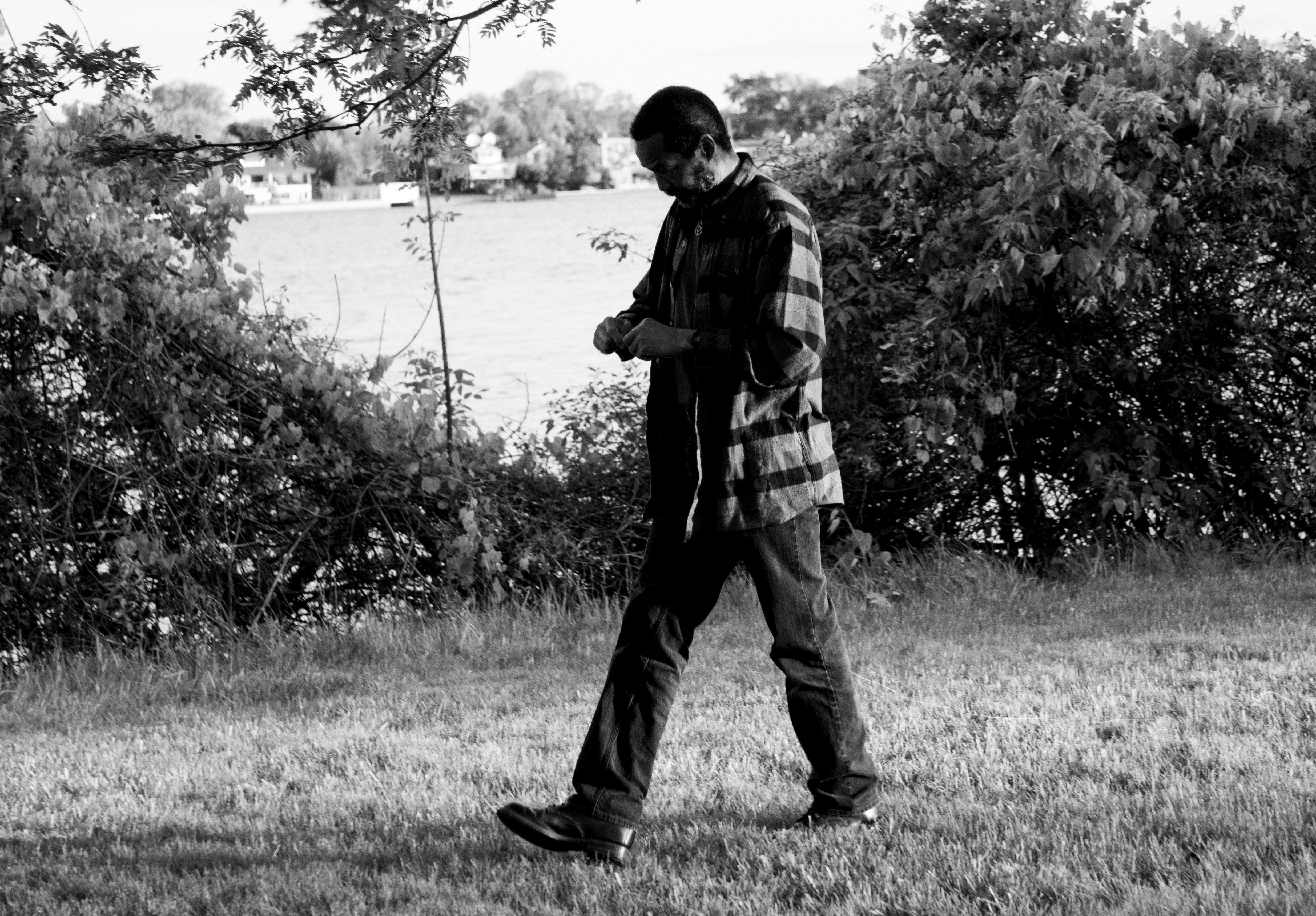 El hombre camina afuera, mirando su reloj.