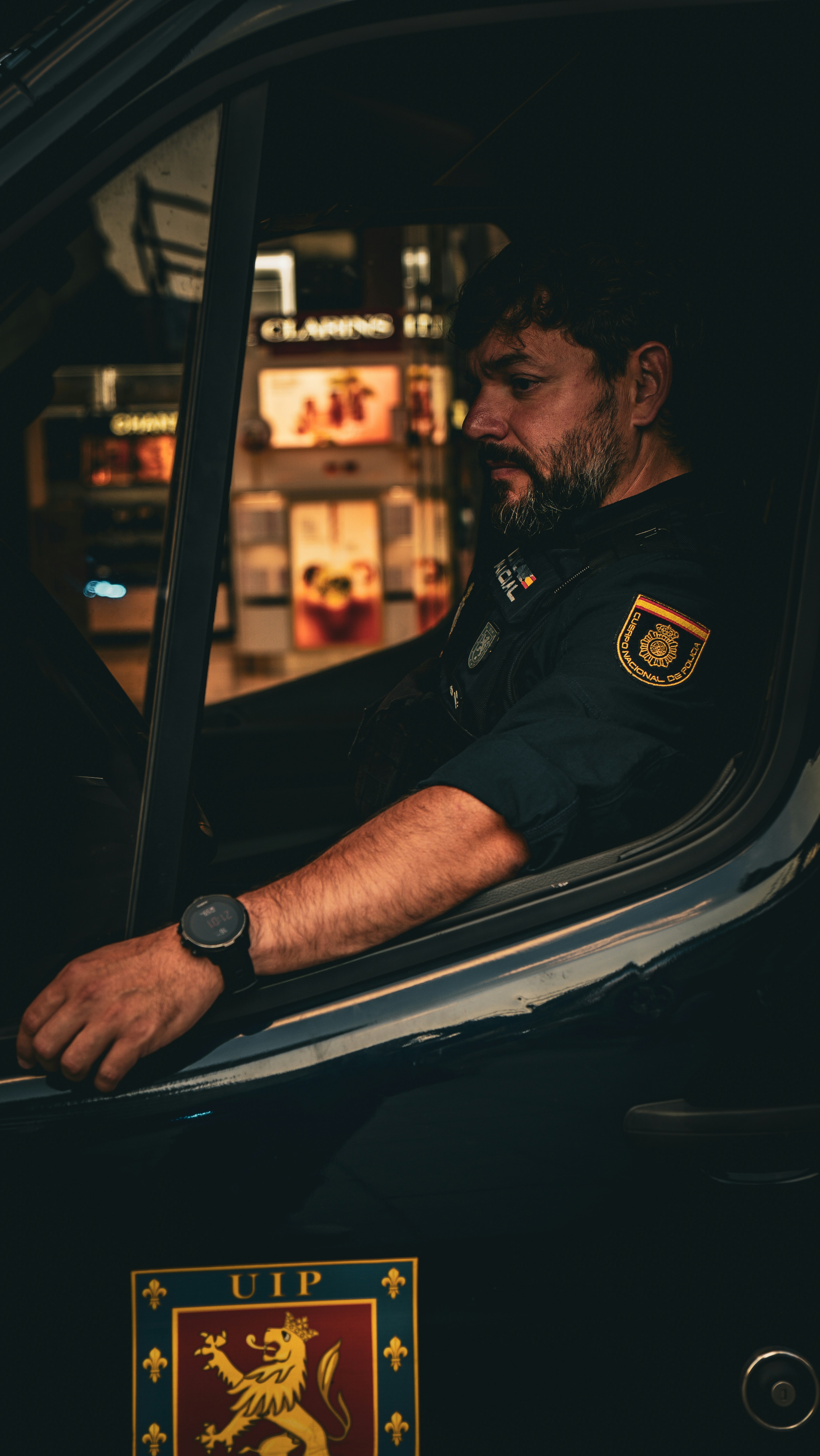 A policeman sits inside of a police vehicle.