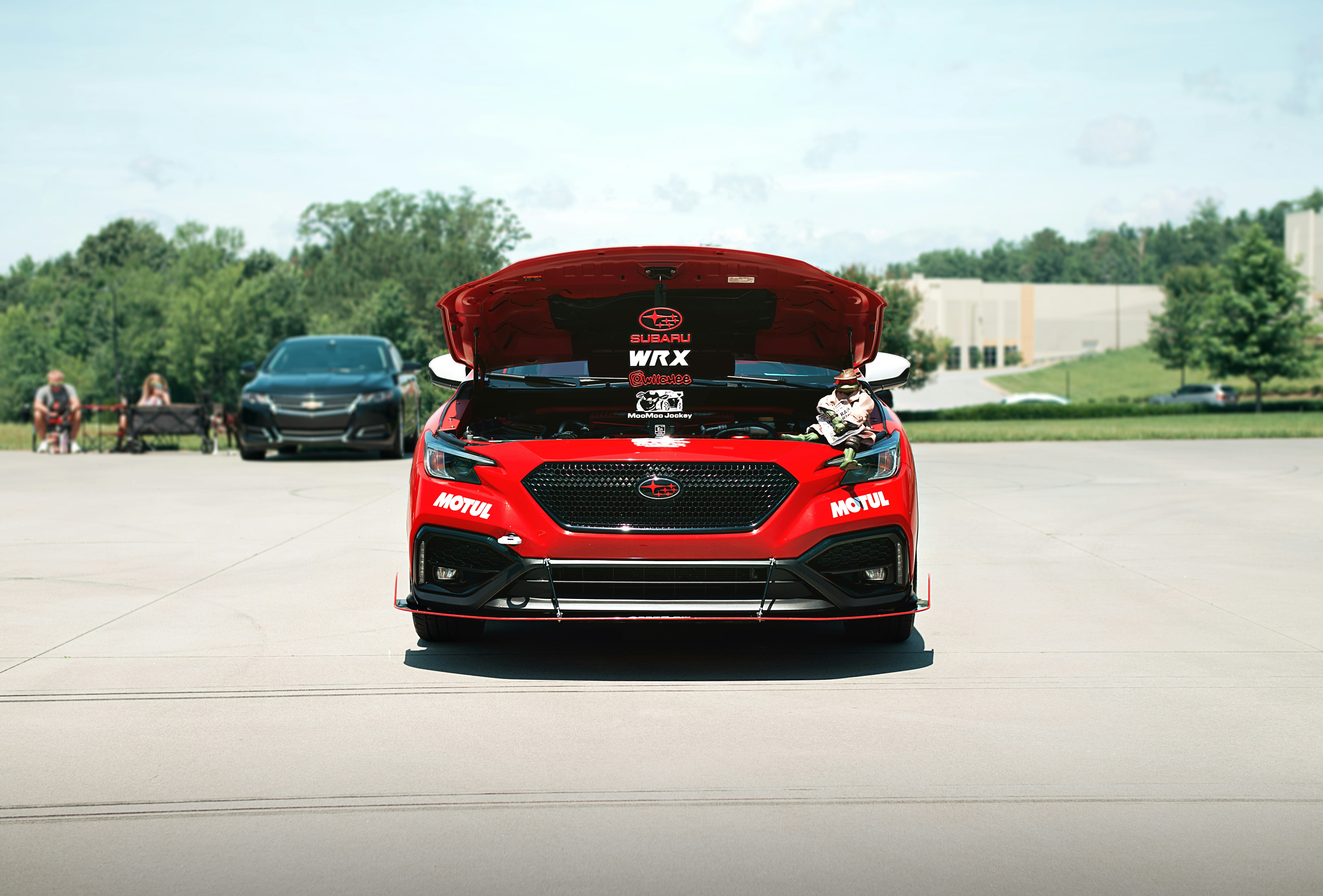 A red racecar has its hood open.