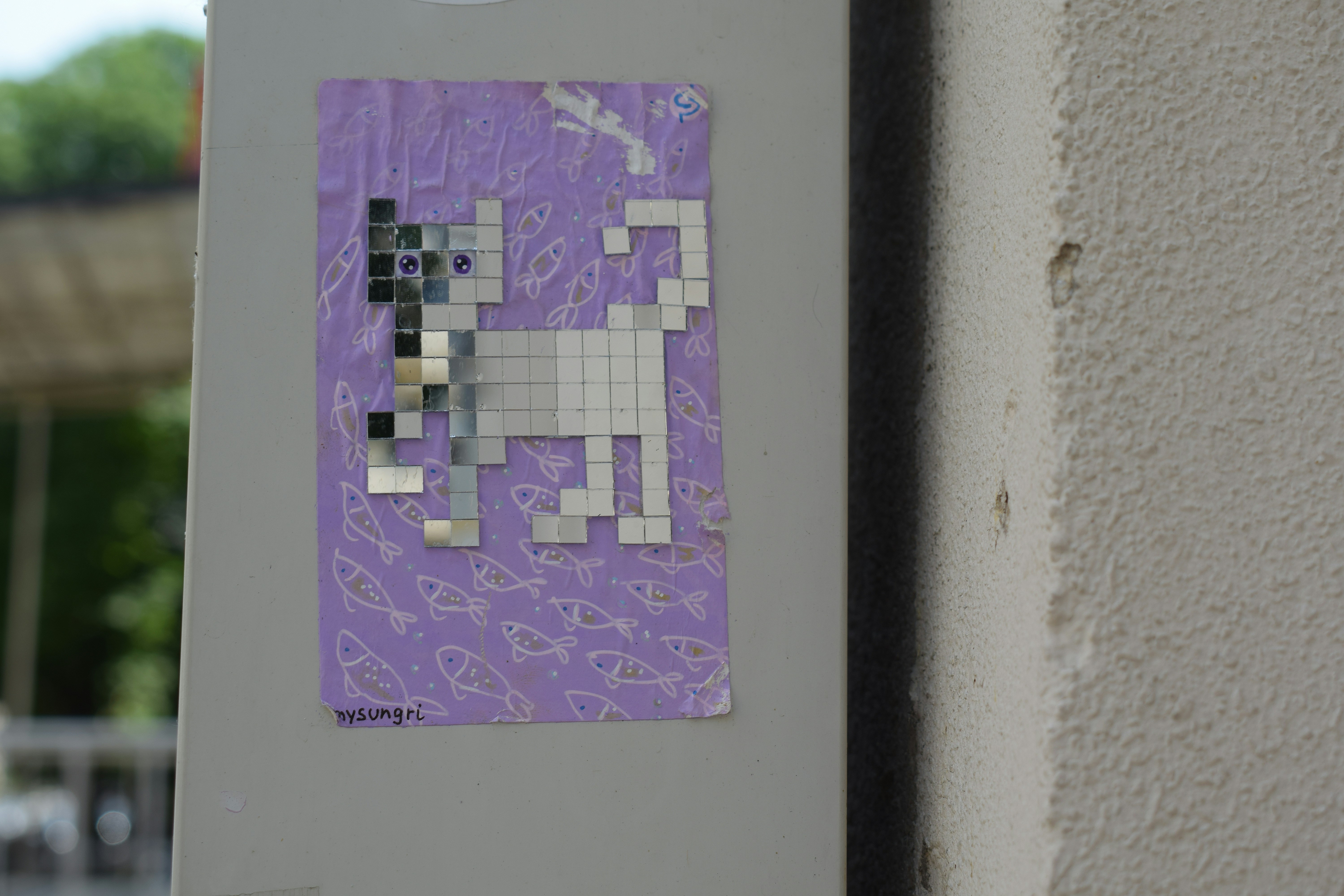 A sticker of a pixelated cat is on the wall.