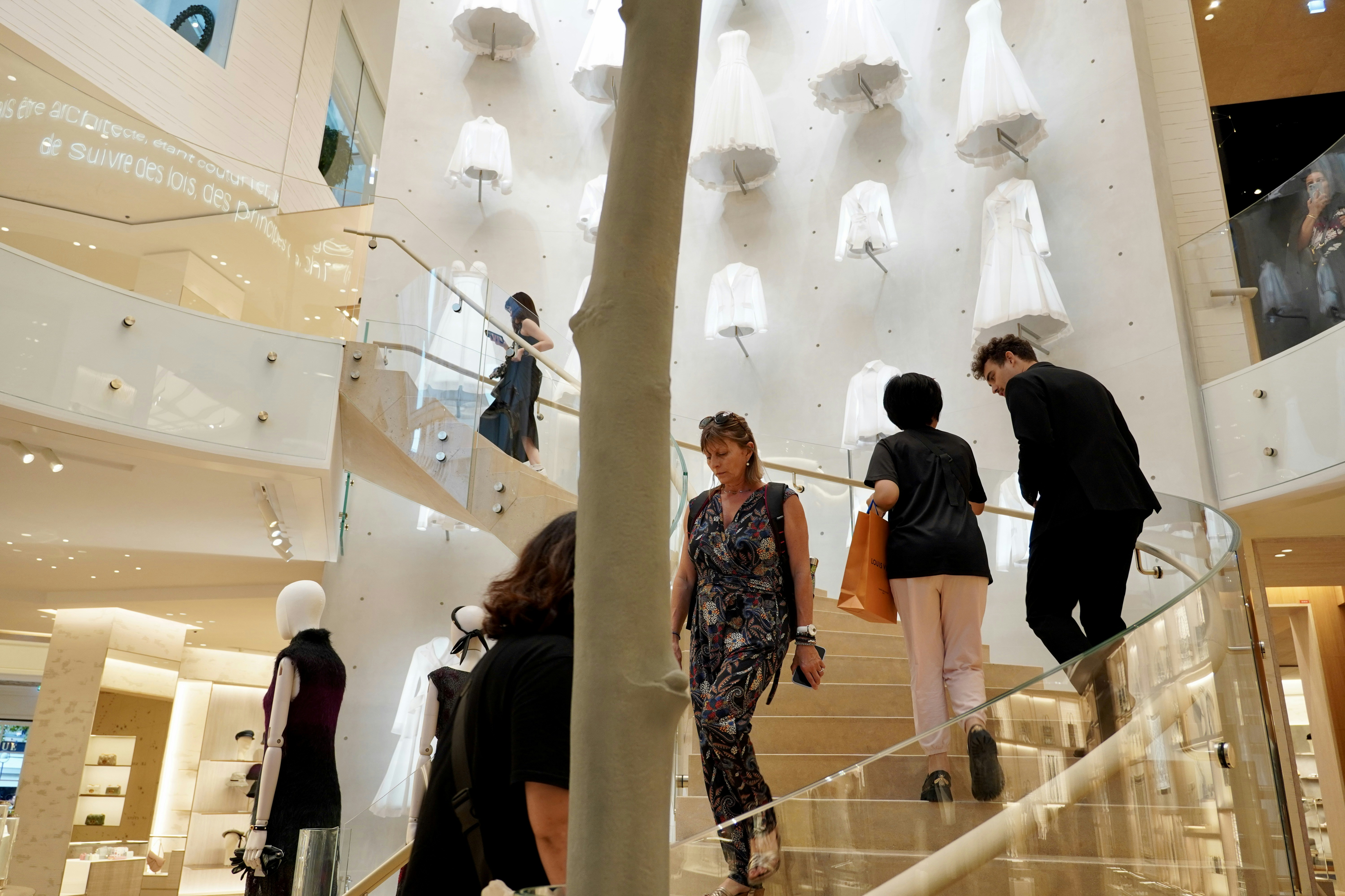 People walk up and down the stairs in a store.