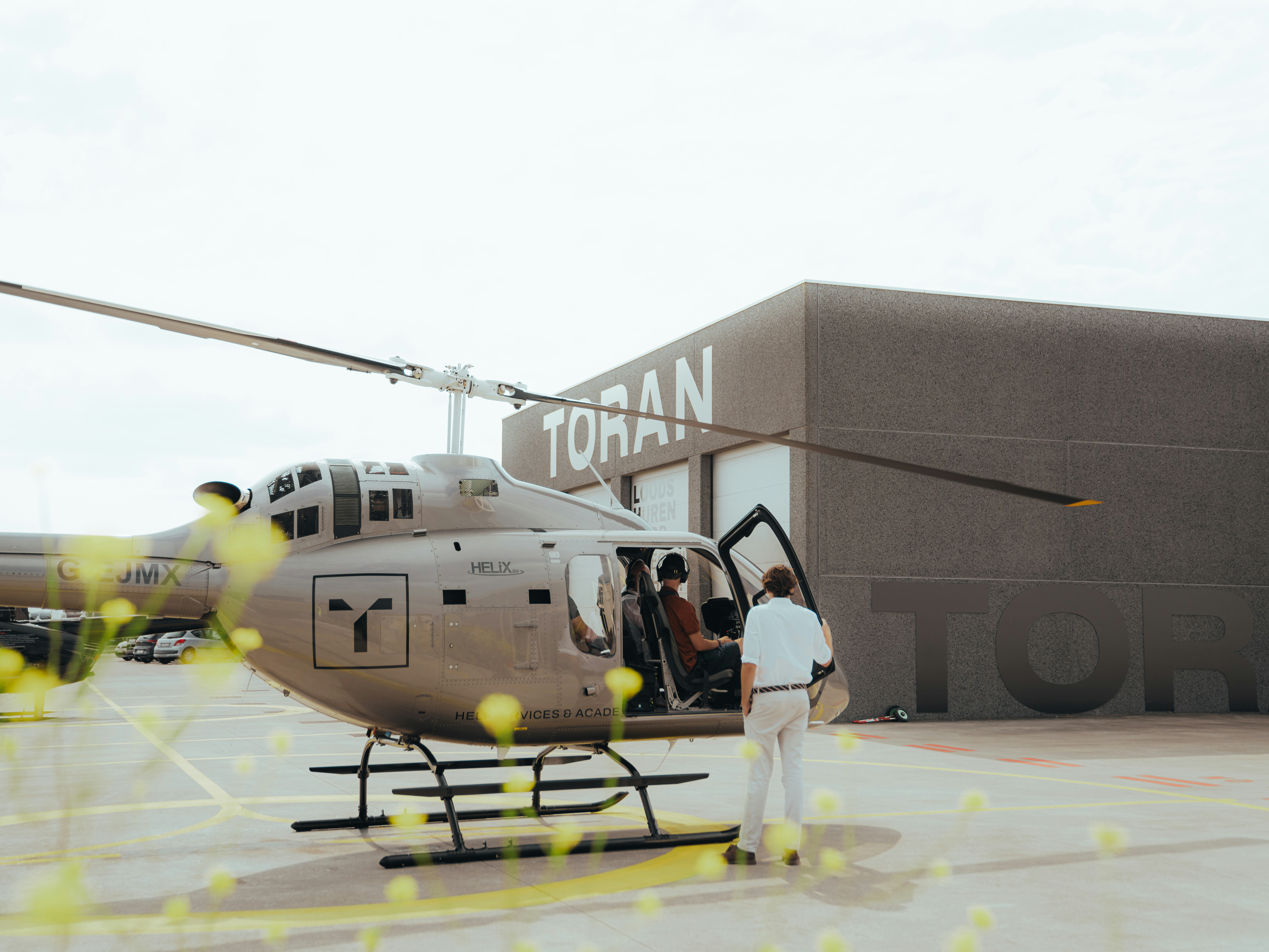 A helicopter lands near a building.