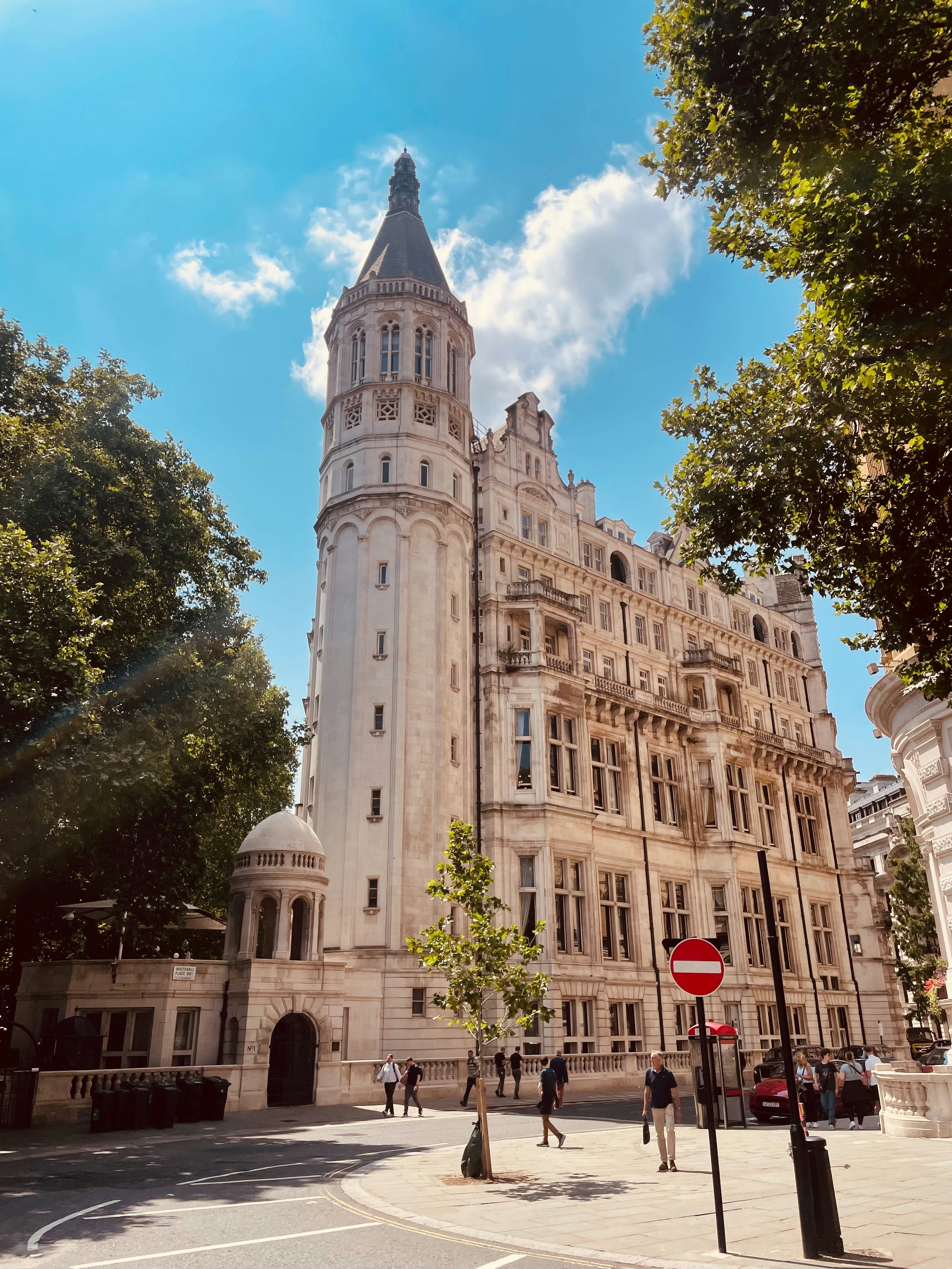A tall, ornate building stands on a sunny street.