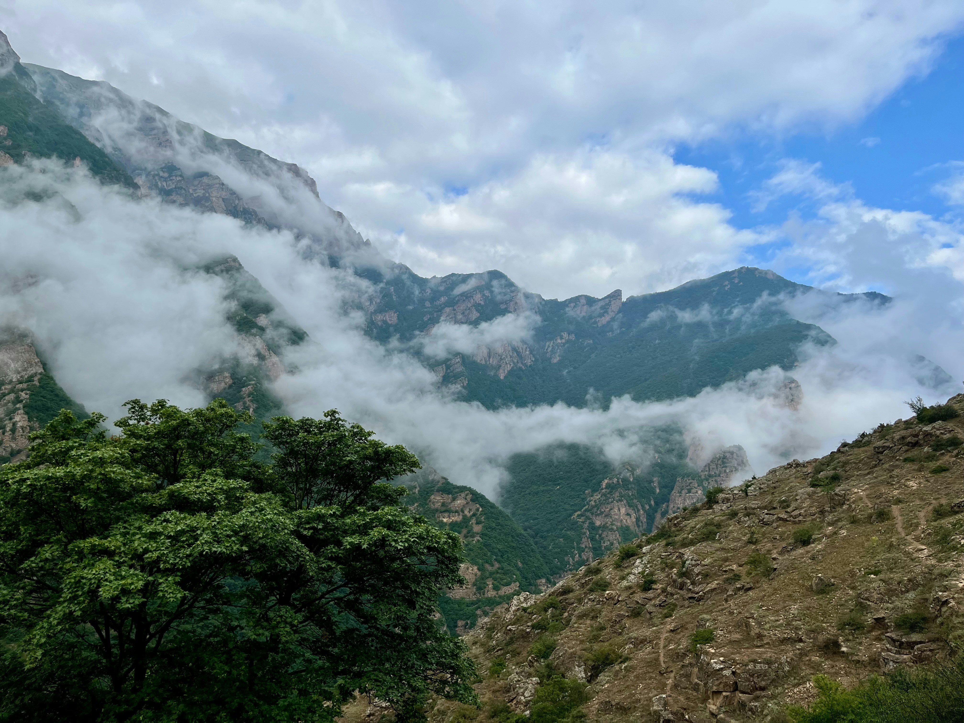 Clouds engulf the majestic mountain peaks.