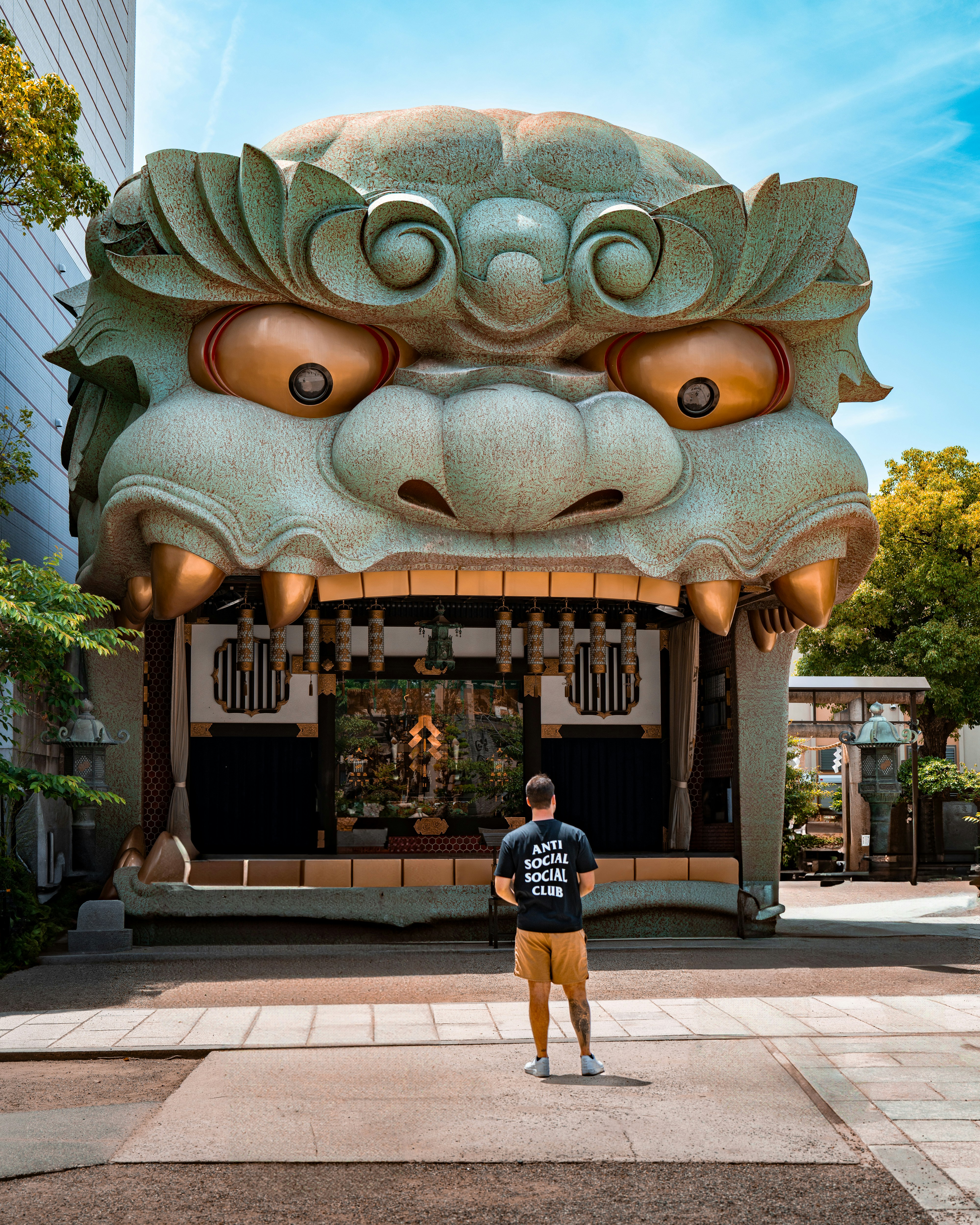 Man stands before a large, carved lion structure.