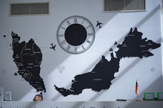 A wall with a map, clock, and airplanes.