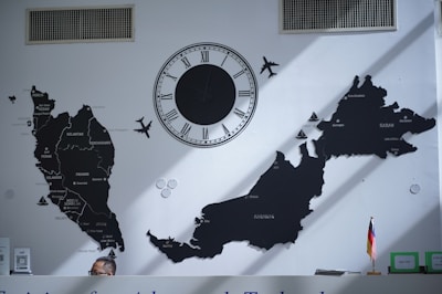 A wall with a map, clock, and airplanes.